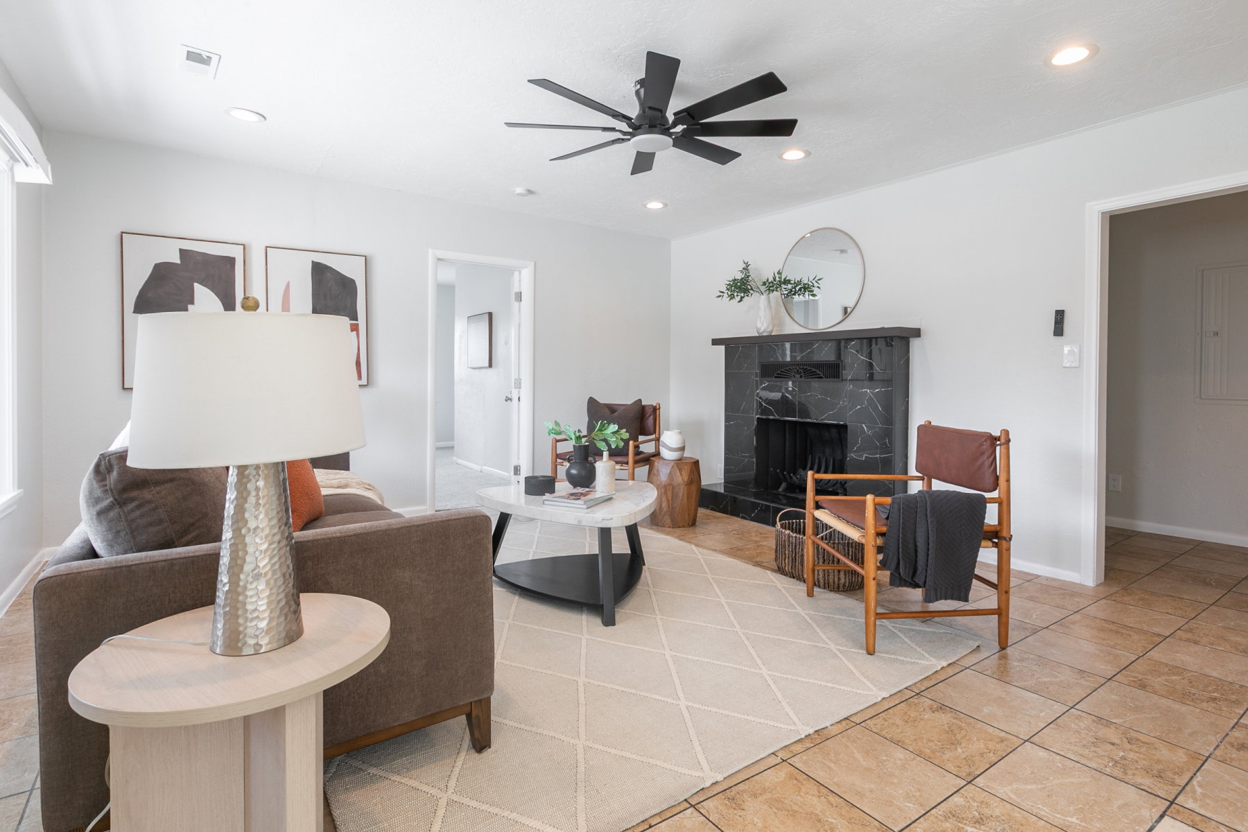 Living area featuring a black marble-patterned fireplace, recessed lighting, and a ceiling fan