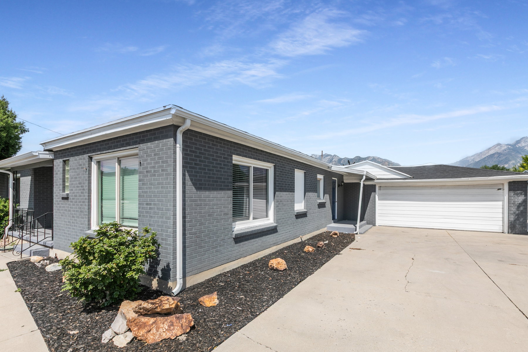 Grey brick exterior with white trim and a two-car garage