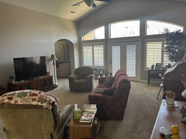 Spacious living area featuring vaulted ceilings and abundant natural light from multiple windows