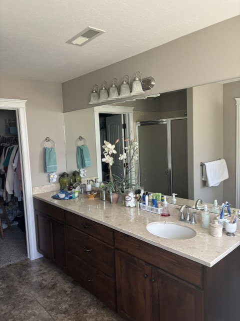 Double vanity featuring undermount sinks, bronze-finish faucets, and an expansive countertop