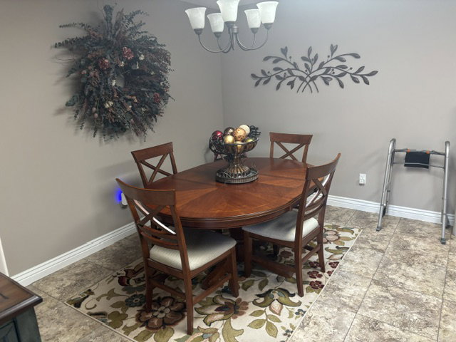 Dining area featuring tile flooring, a detailed area rug, and a ceiling-mounted chandelier