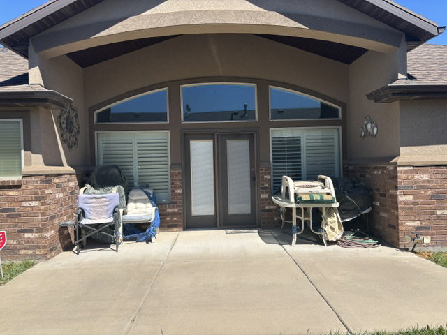 Expansive concrete patio area with a stucco and brick facade