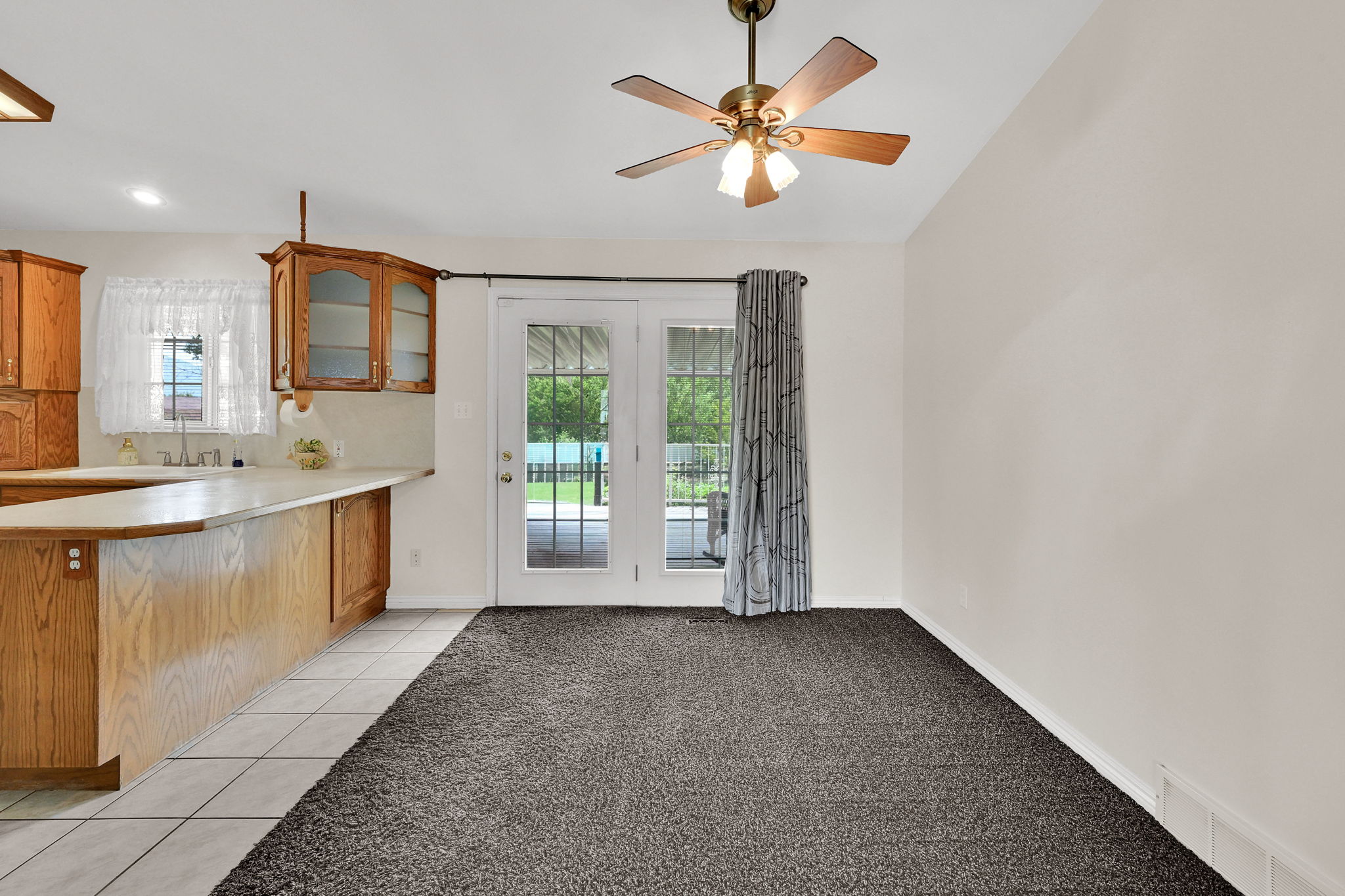Kitchen area featuring wood cabinetry, white tile flooring, and a breakfast bar