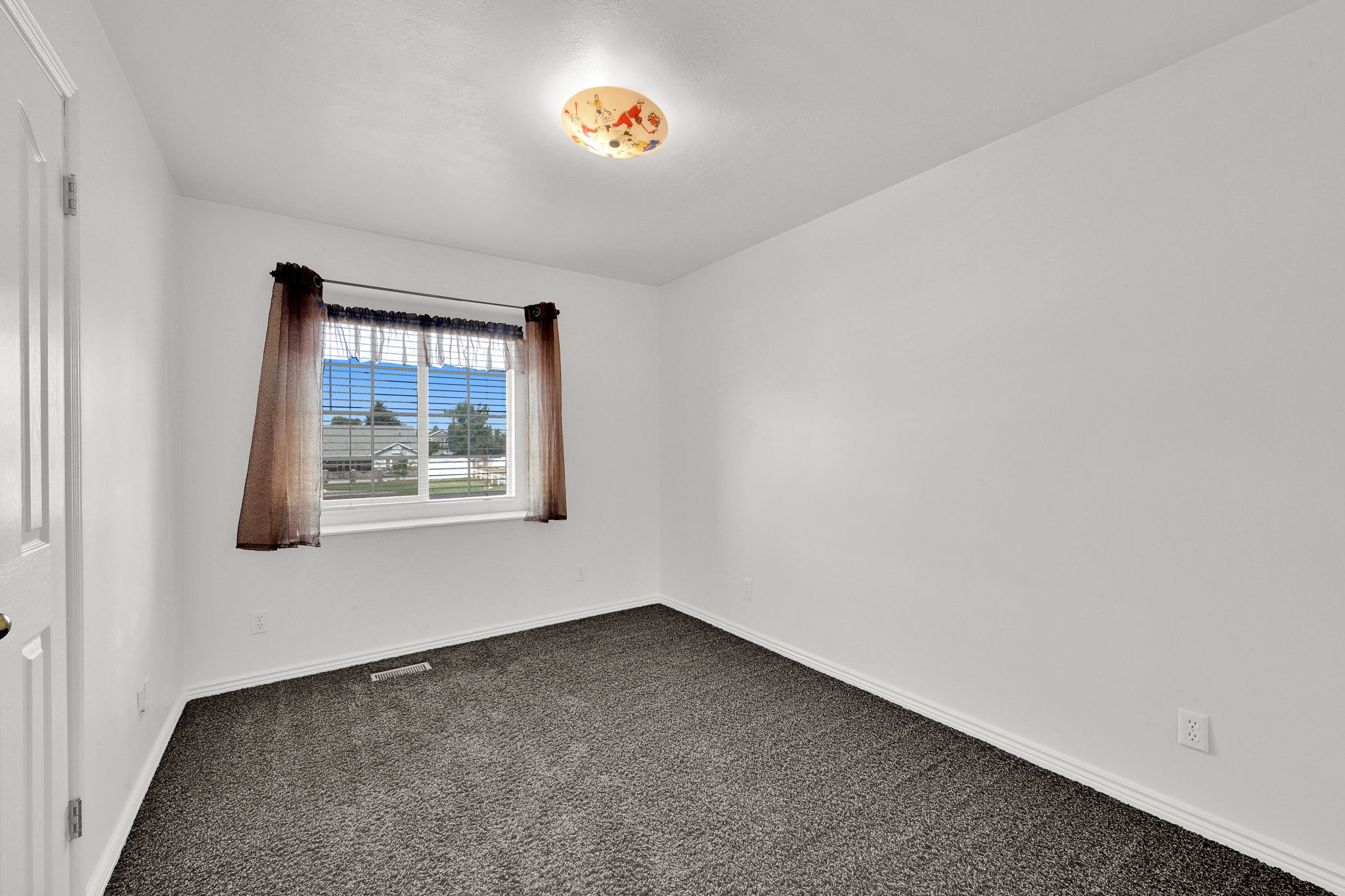 Room with neutral wall paint and dark carpet flooring