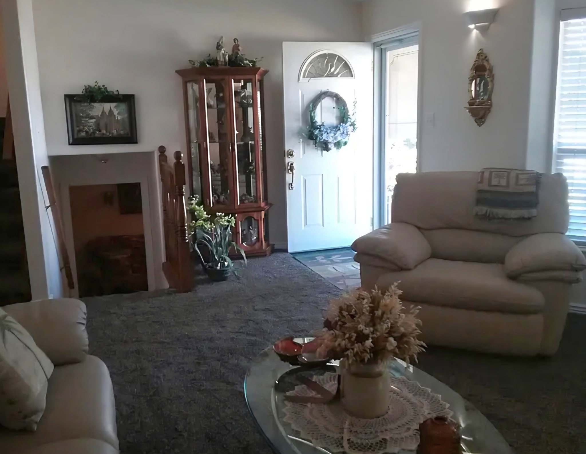 Entryway featuring a white paneled door with an arched glass insert, flanked by a double-paned window with blinds