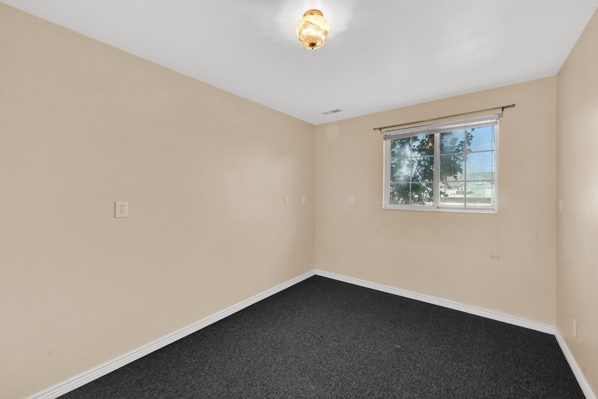 Neutral-toned walls complement the dark carpeting