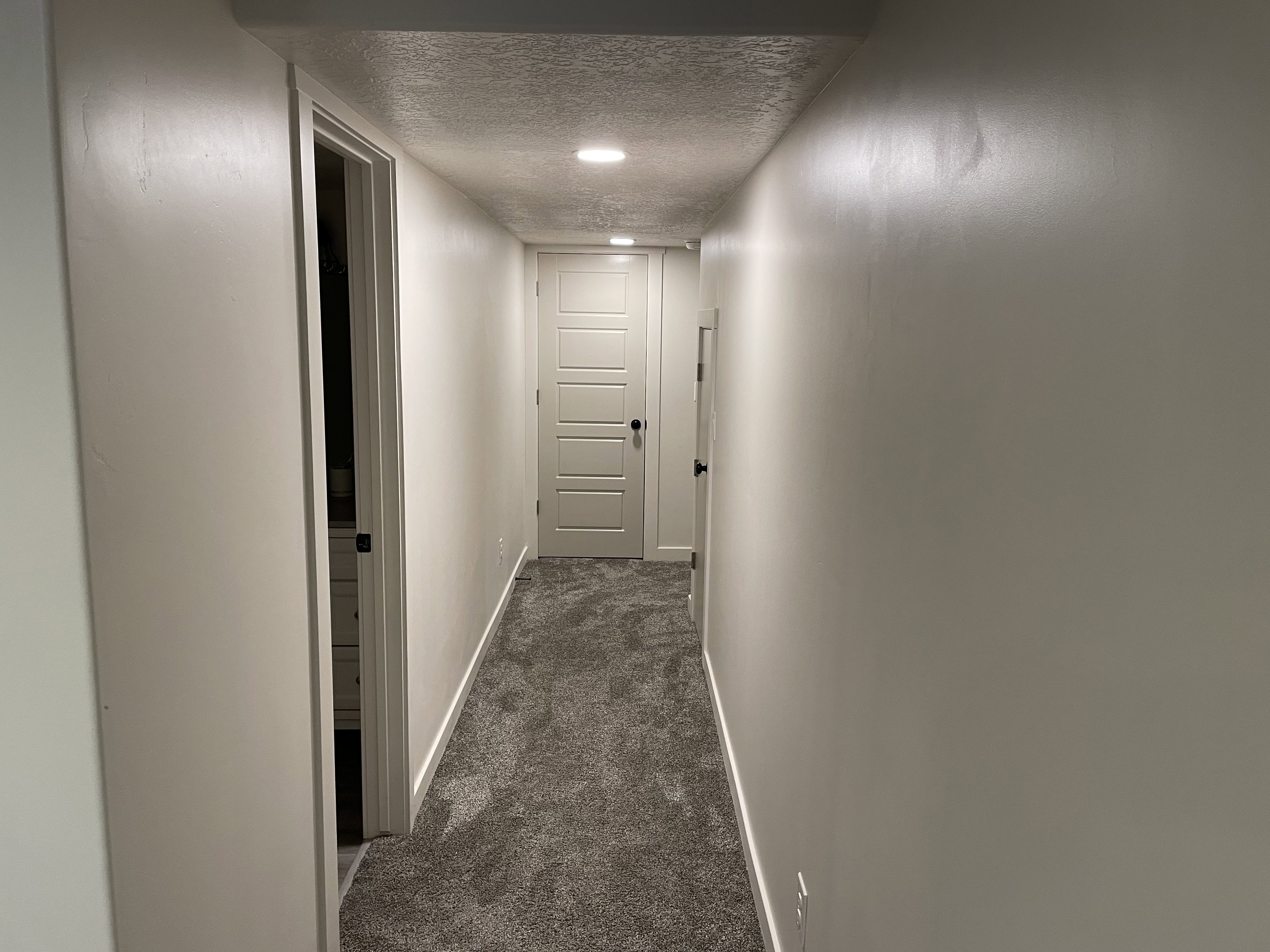 Hallway featuring neutral-toned walls, recessed lighting, and grey textured carpeting