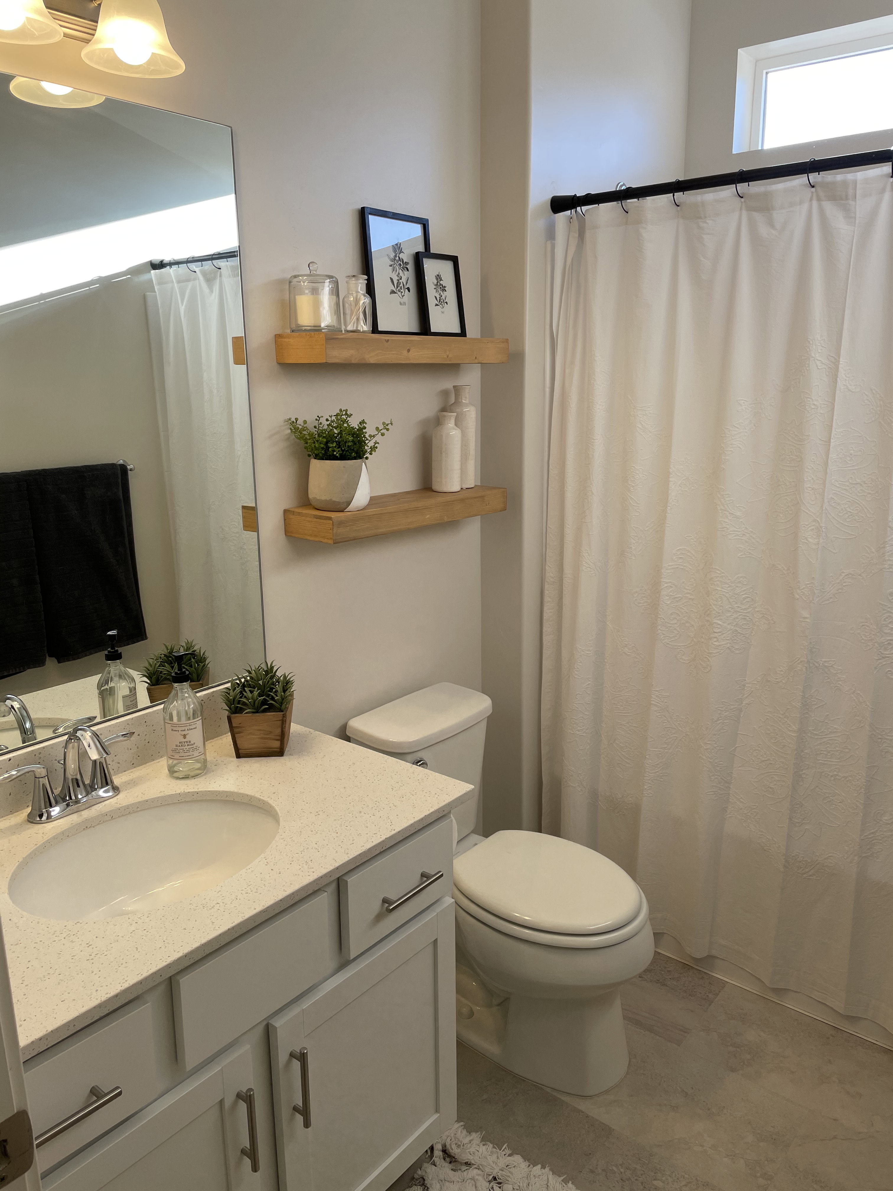 Bathroom featuring a single vanity with a light-colored countertop, an oval sink, and a chrome faucet