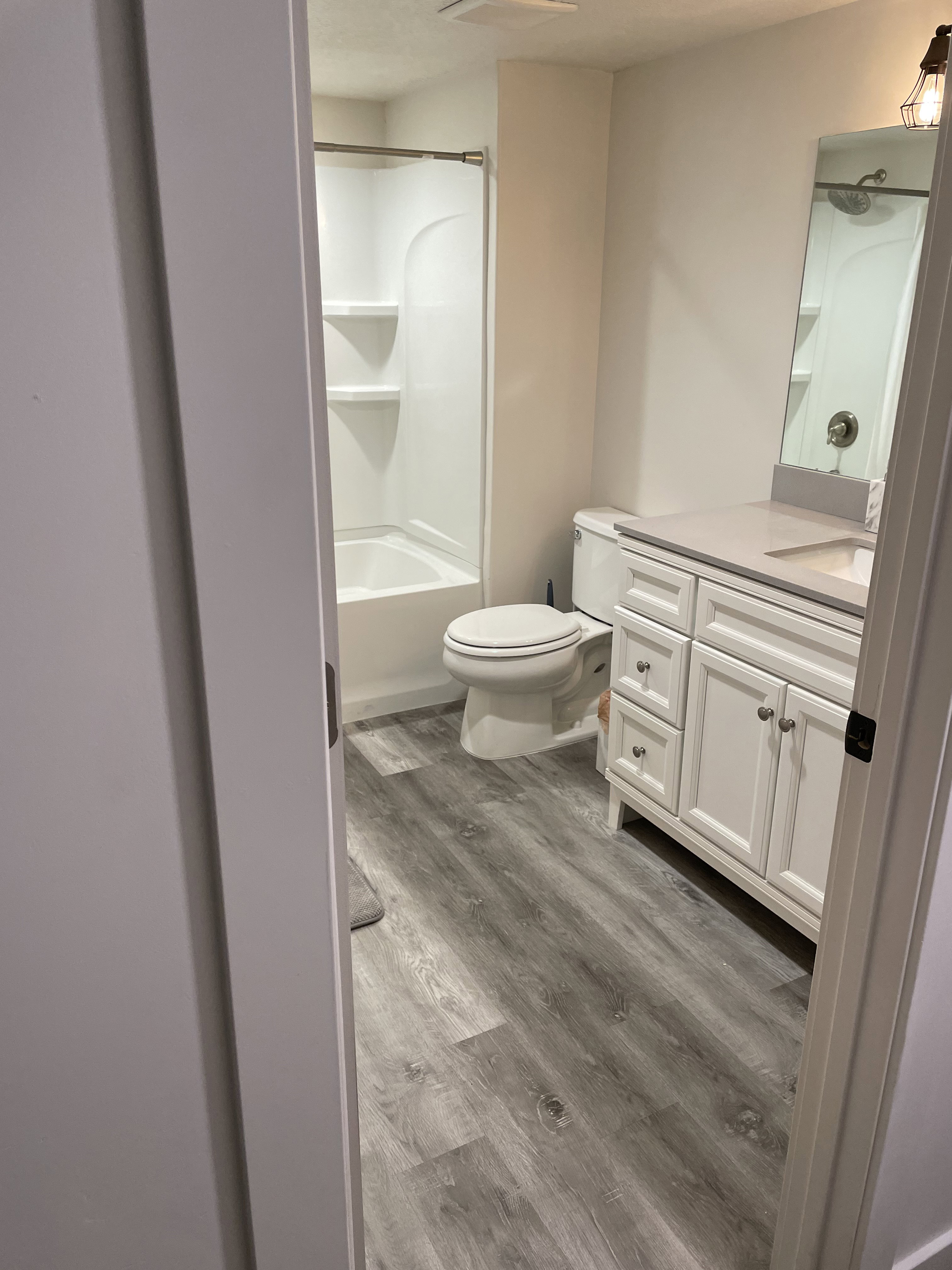 Bathroom featuring a white vanity with a light-colored countertop, a chrome faucet, and a large mirror