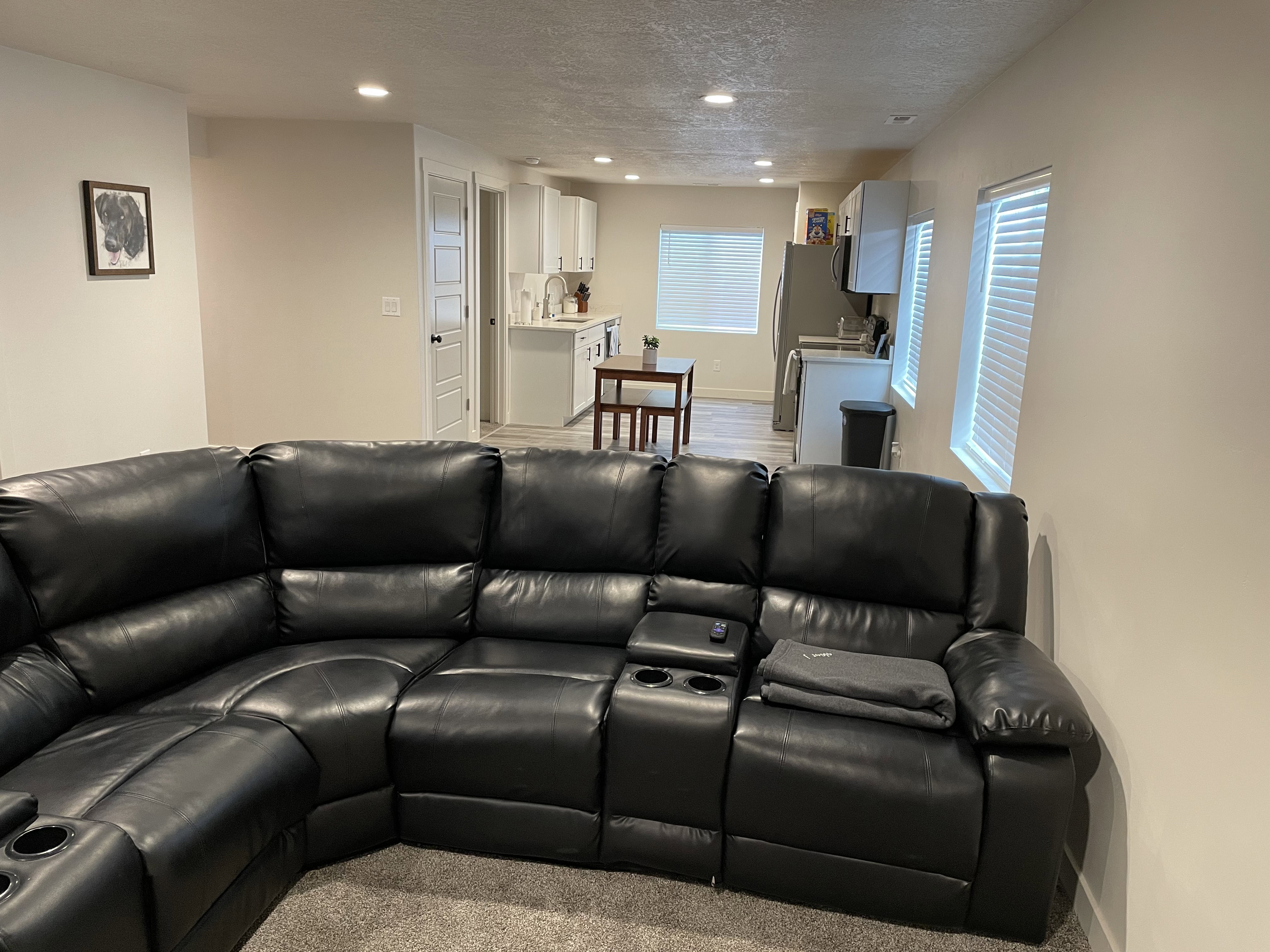 Lower level living area featuring recessed lighting, a white panel door, and neutral wall tones