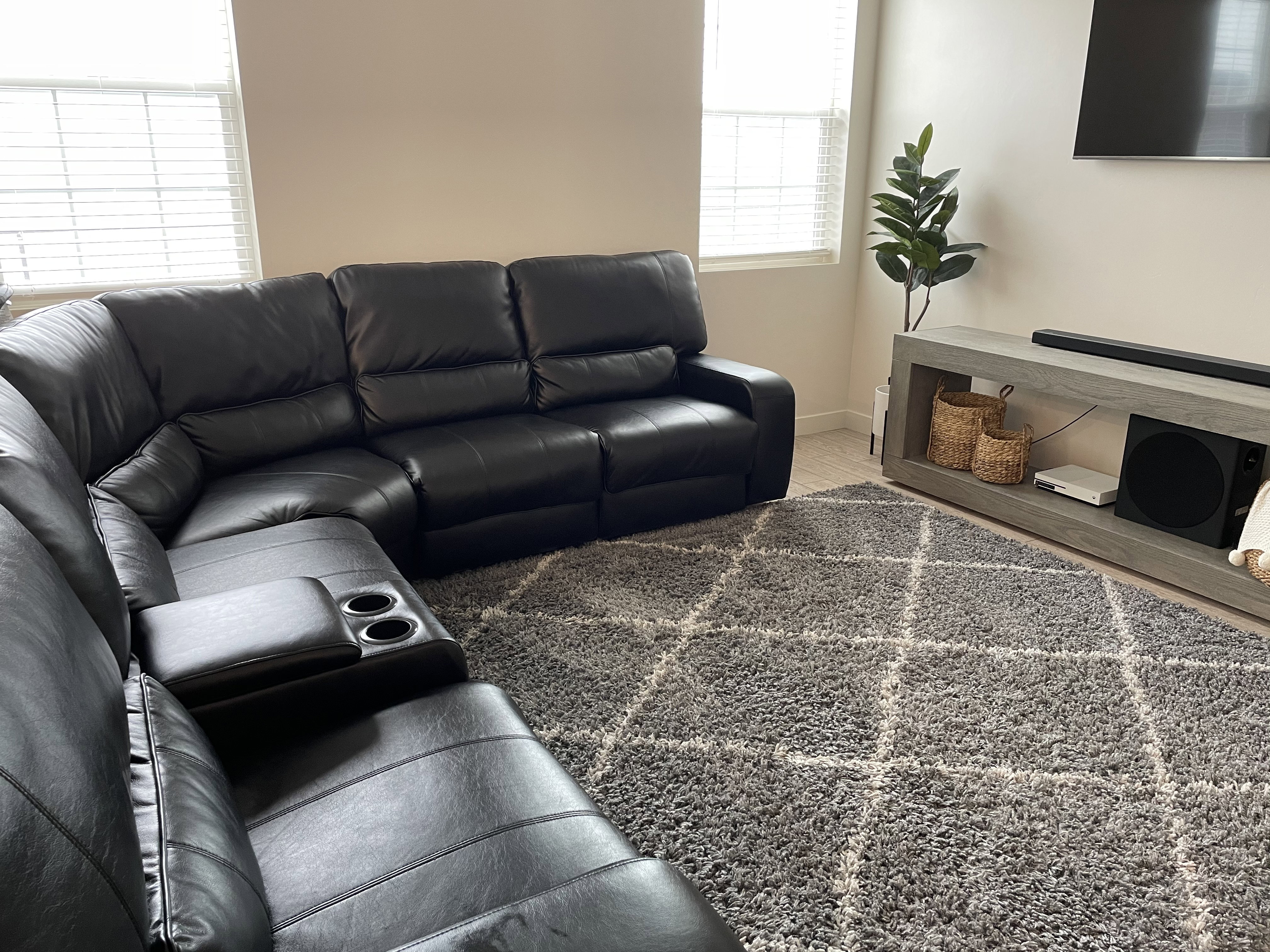 Light-toned walls with corner window placement, neutral-toned flooring, and a built-in media console