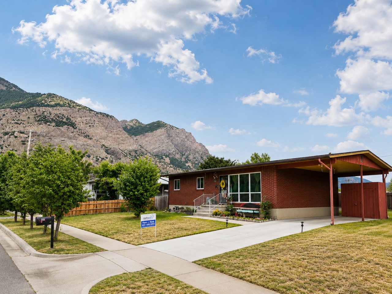Single-story brick residence featuring a carport, front yard, and concrete driveway