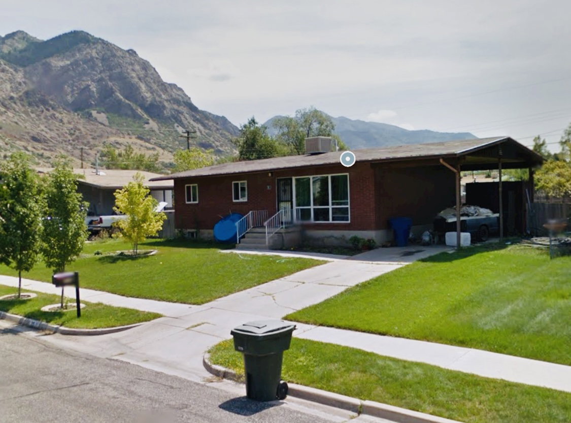 Brick ranch-style residence featuring a prominent mountain backdrop