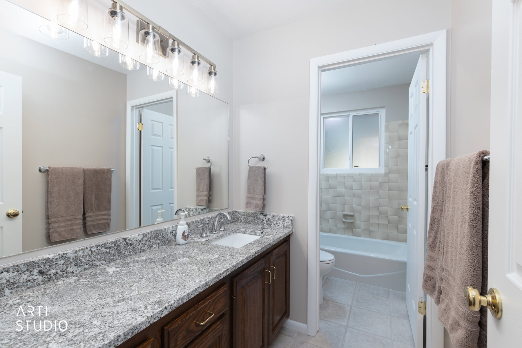 Bathroom vanity featuring a speckled countertop, a rectangular undermount sink, and a brushed nickel faucet