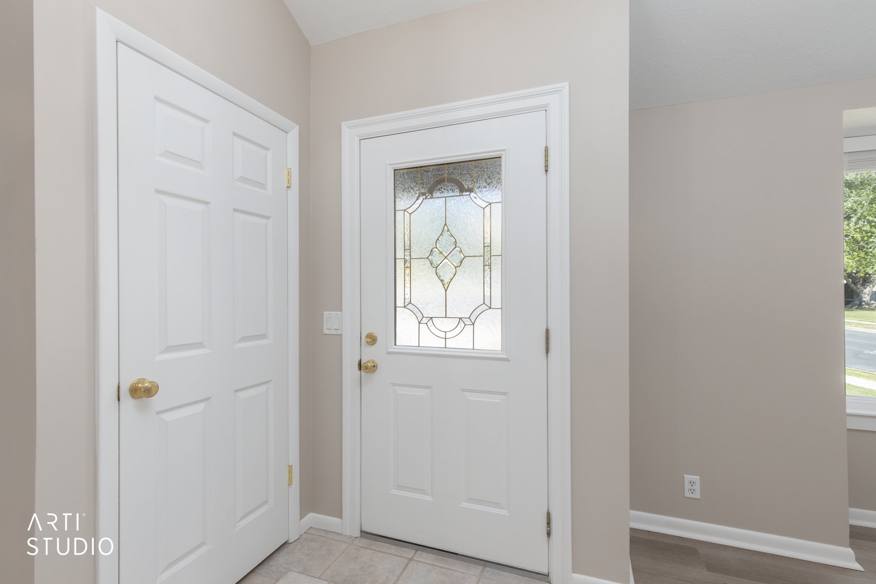 Entryway featuring a decorative glass panel door, neutral wall paint, and a tiled floor