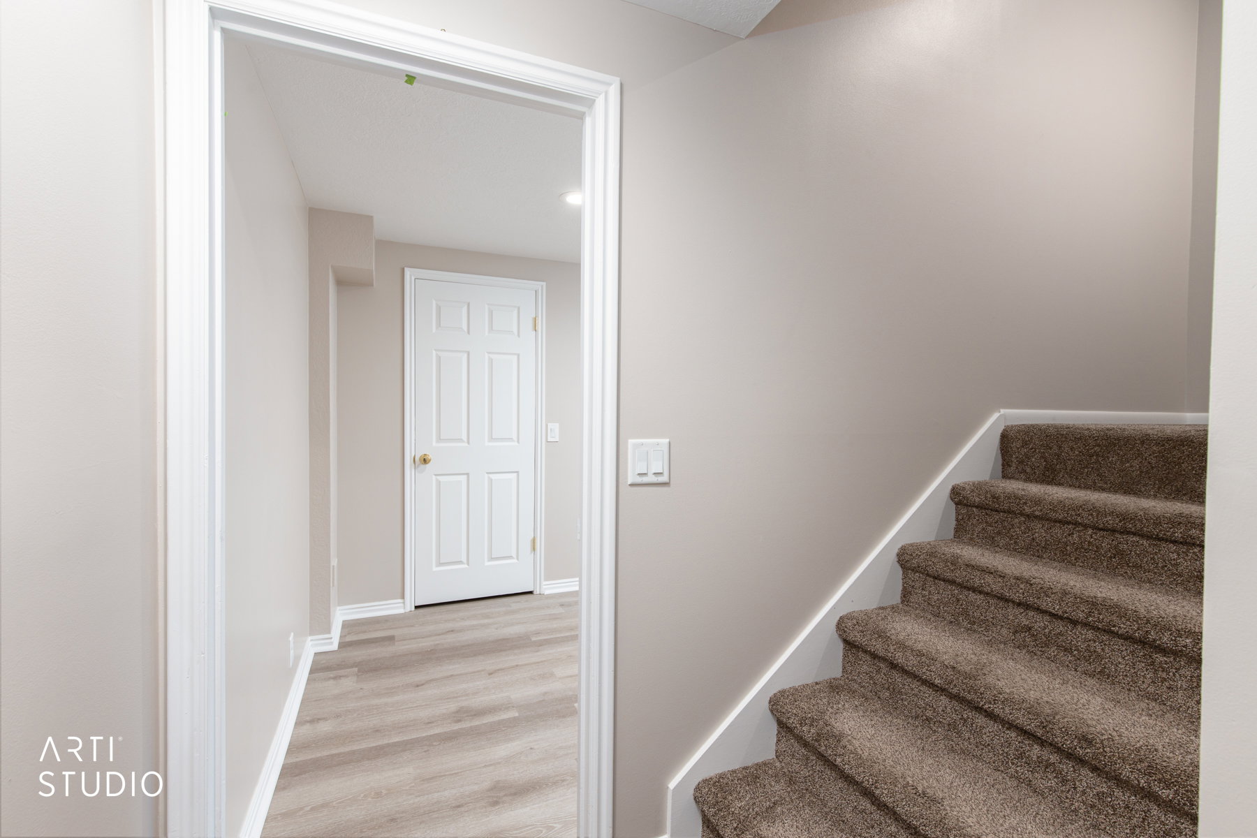 Interior doorway revealing a hallway with light wood-finish flooring