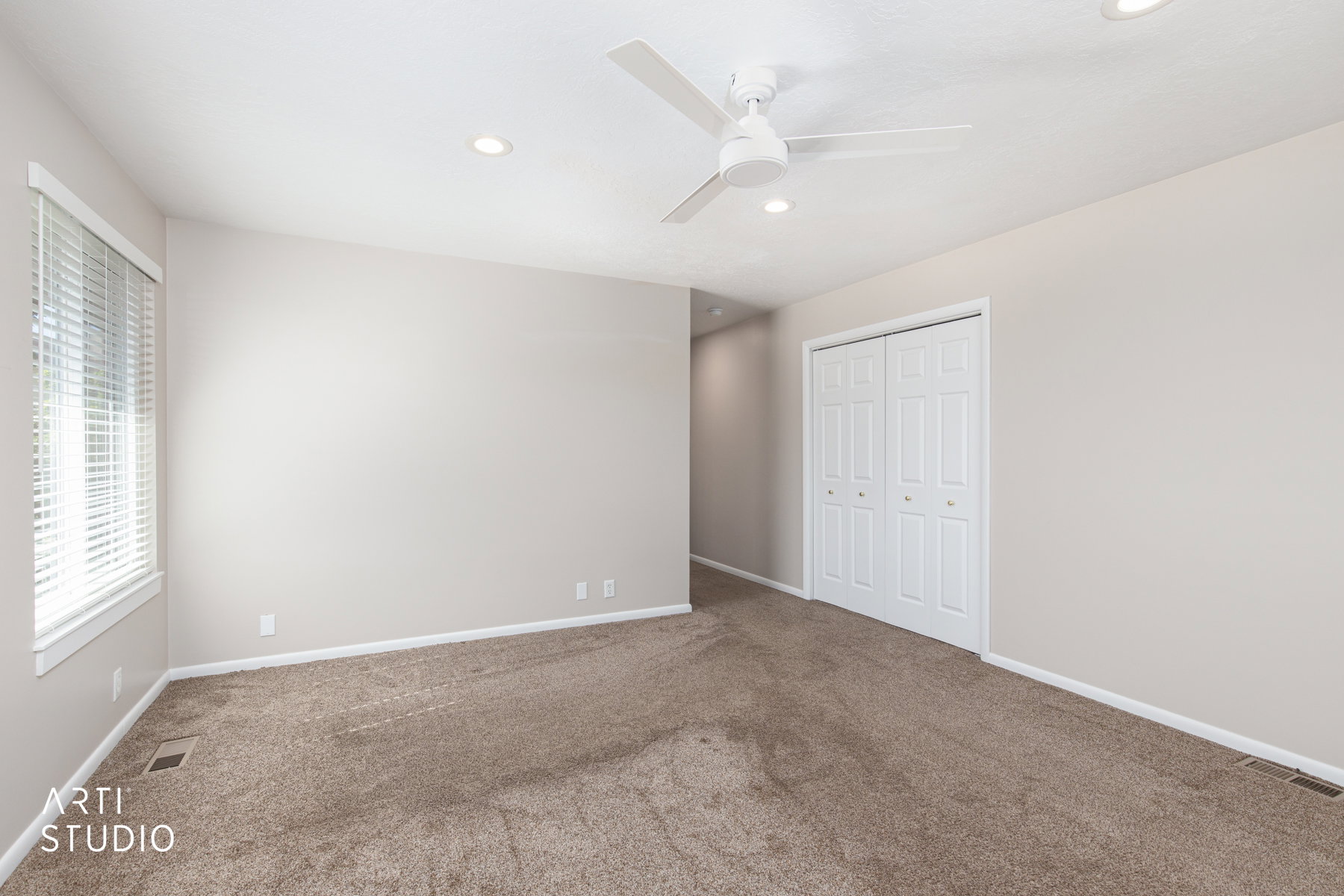 Carpeted room featuring a ceiling fan, recessed lighting, double bi-fold closet doors, and a window with horizontal blinds