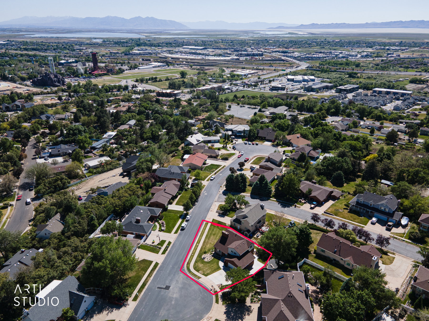 Aerial perspective showcasing a residential neighborhood with a distant body of water and mountains