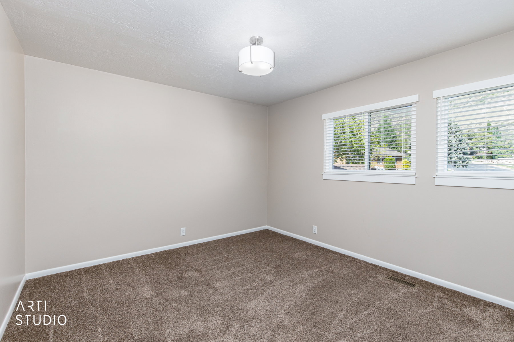 Neutral-toned walls complement the textured brown carpeting
