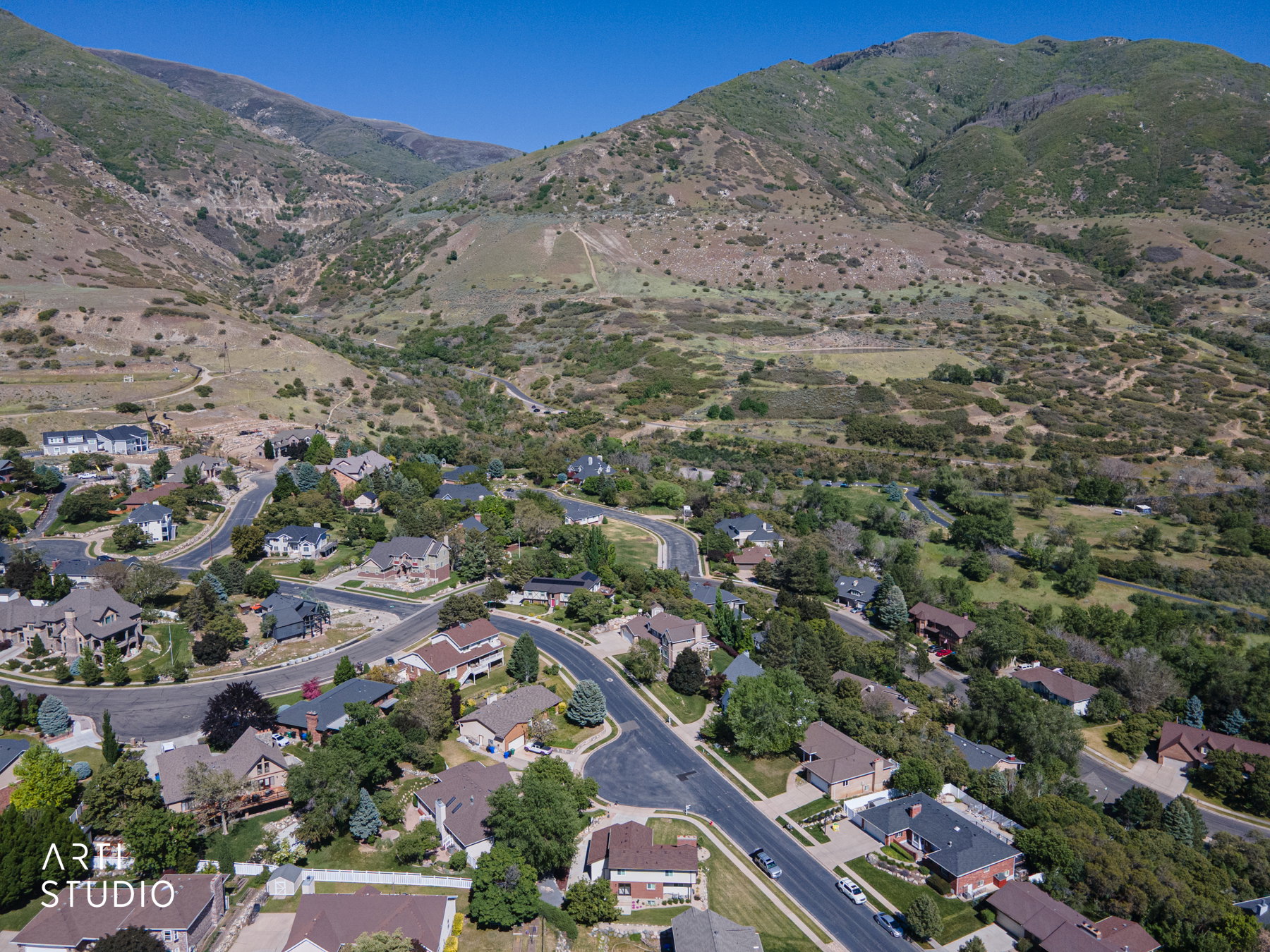 Community situated within a mountainous landscape, featuring residential properties with varying architectural styles