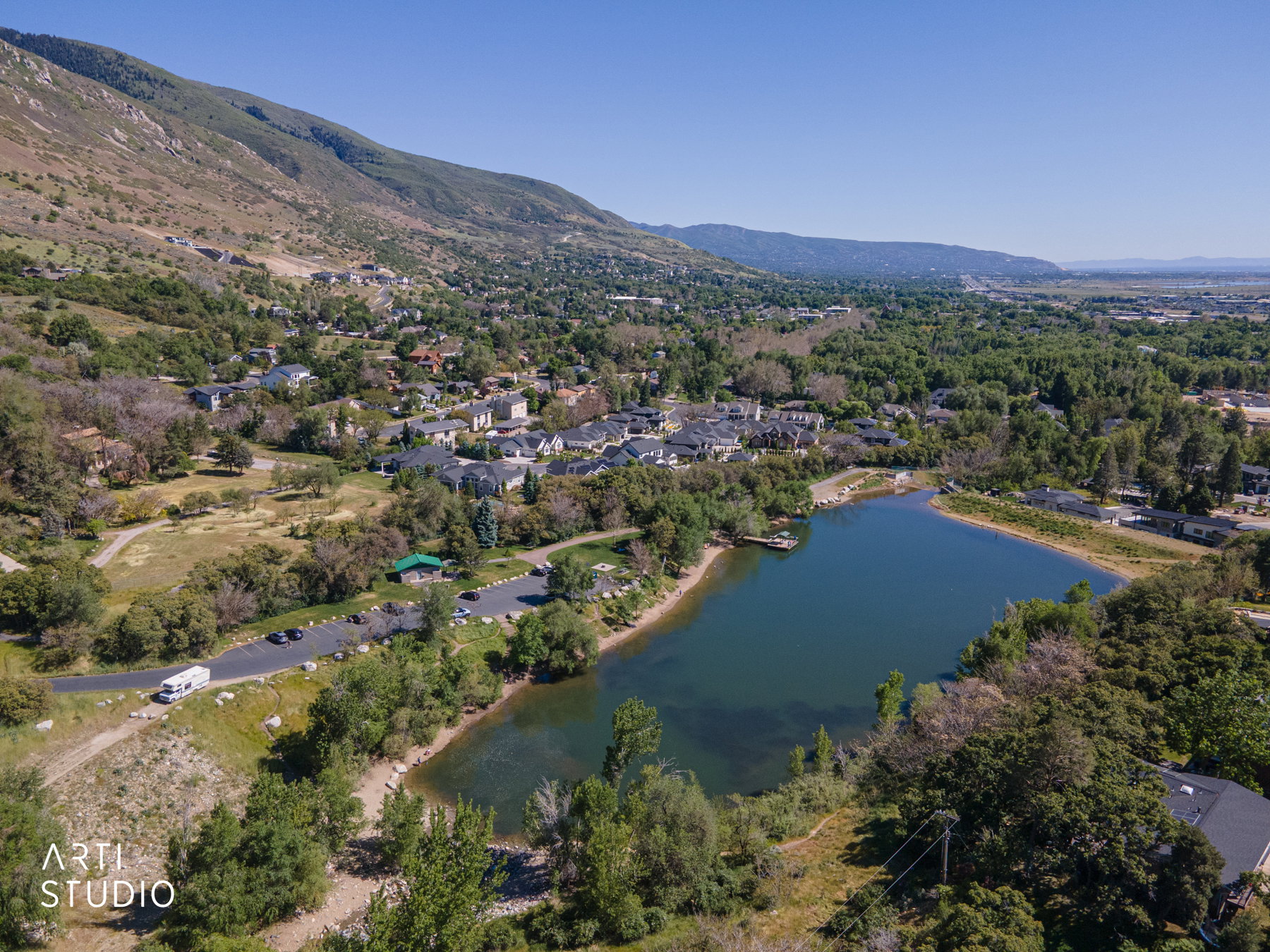 Aerial landscape featuring a large body of water, a cluster of residential properties, and extensive green space
