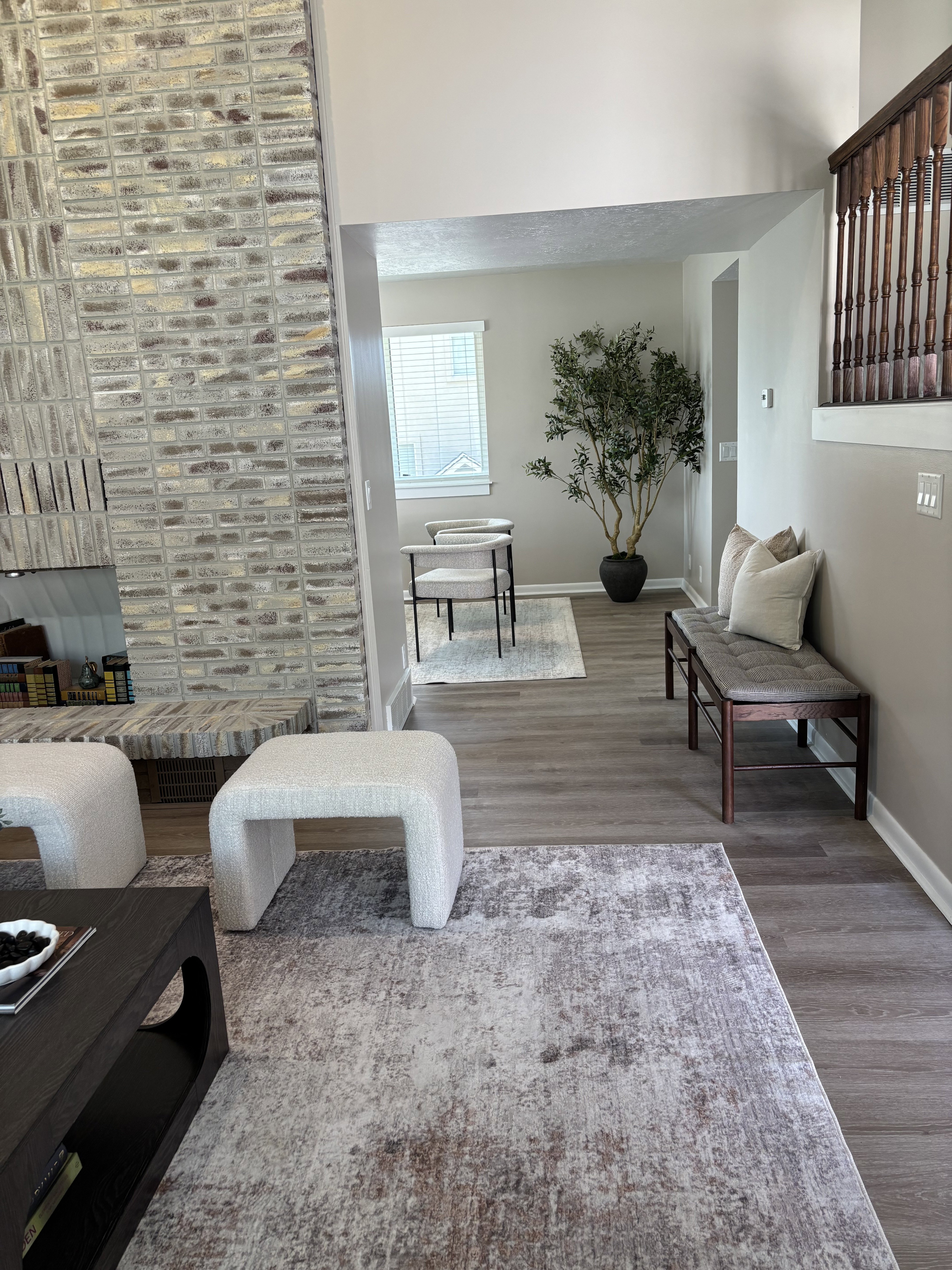 Open-concept interior featuring wood-finish flooring, a contemporary brick fireplace, and a light-filled dining area