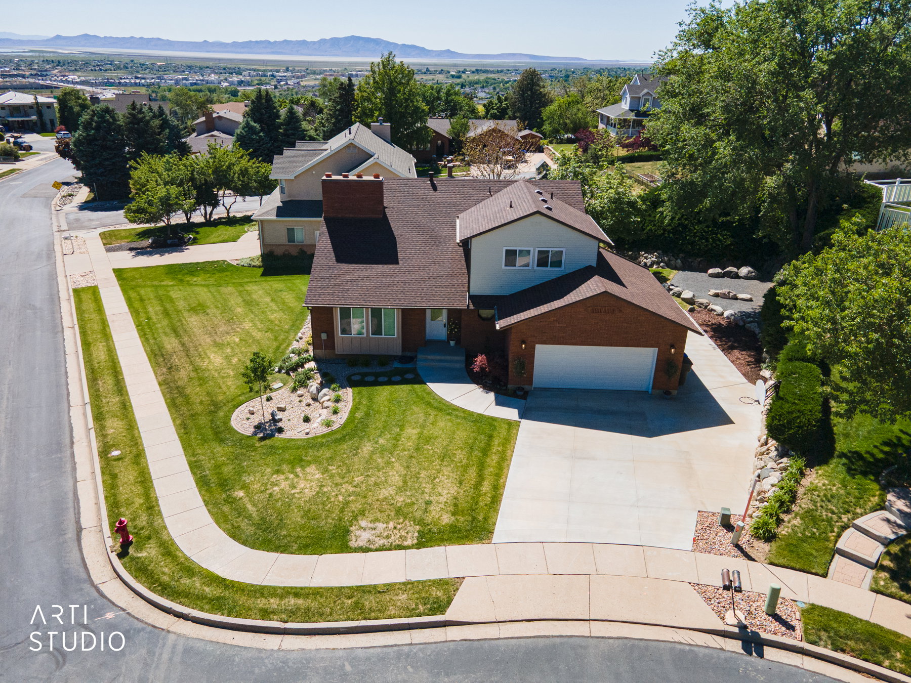 Traditional two-story residence featuring a two-car garage, mature landscaping, and a corner lot