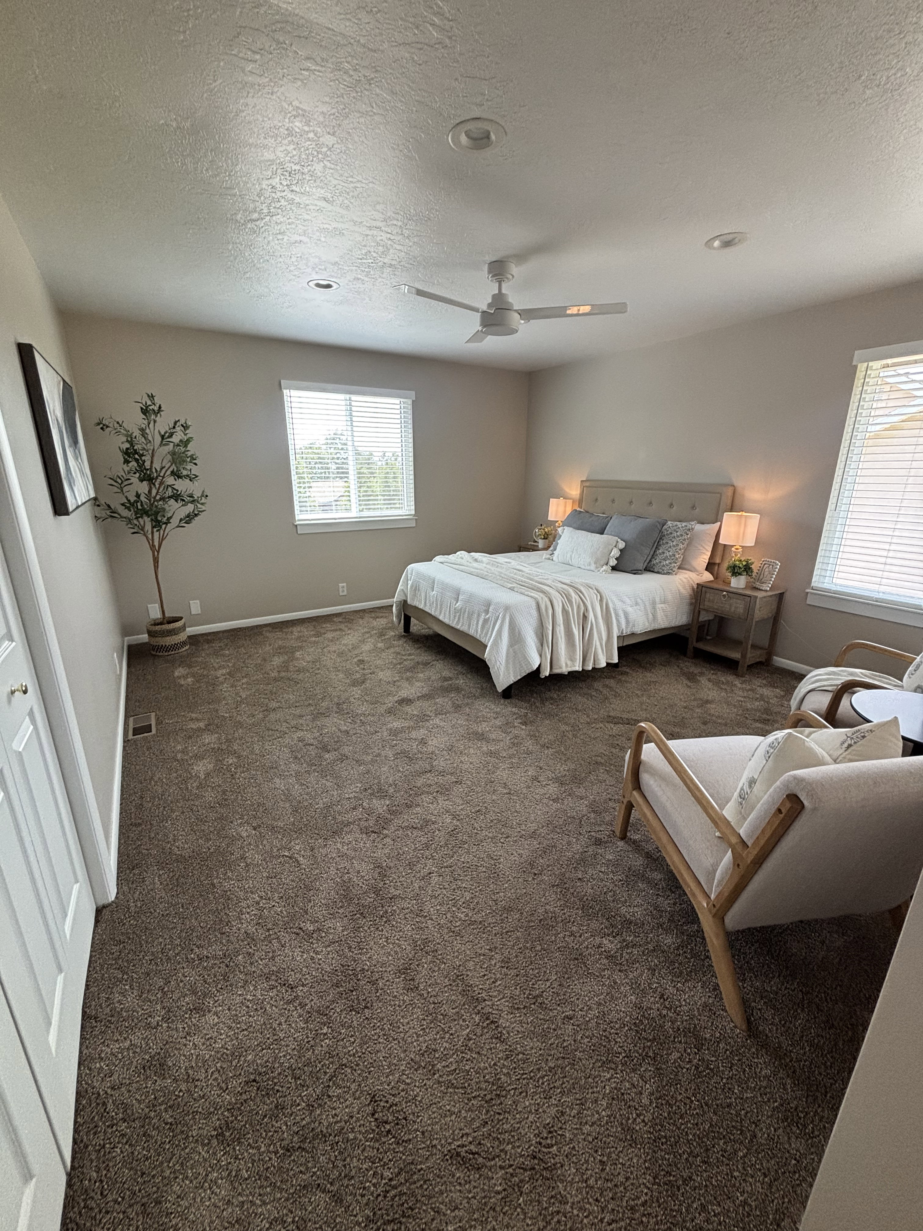 Spacious room featuring neutral-toned walls and plush brown carpeting
