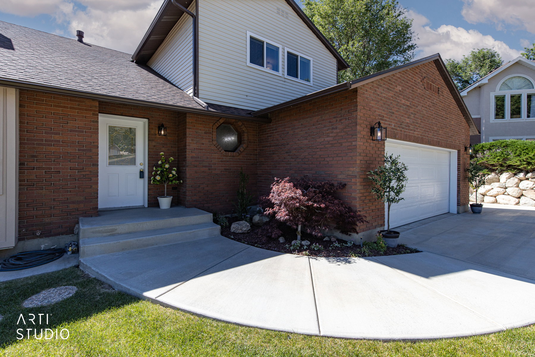 Brick exterior with a white entry door and a two-car garage