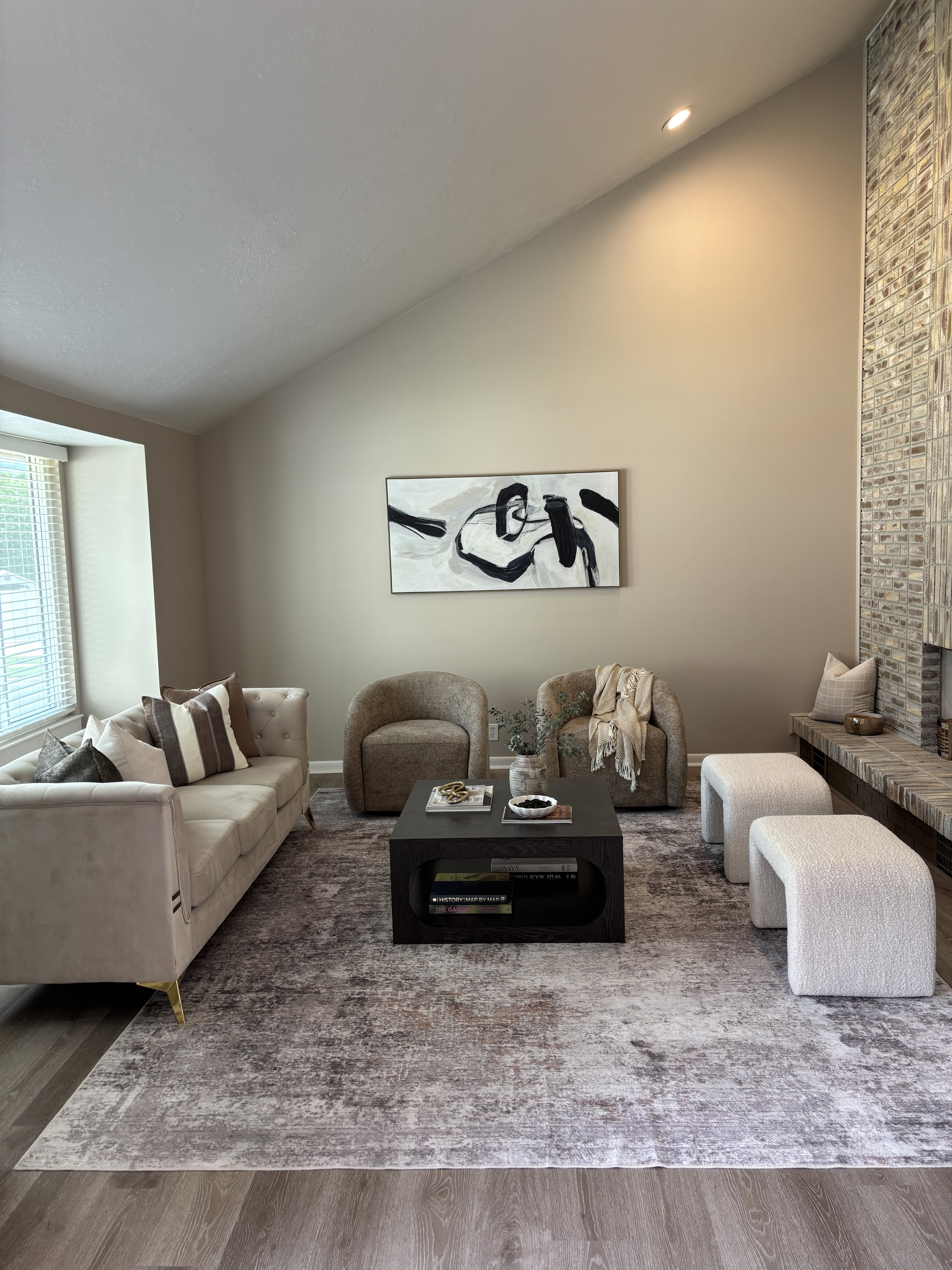 Vaulted ceiling living area featuring wood-finish flooring, a large window with blinds, a built-in bench, and recessed lighting