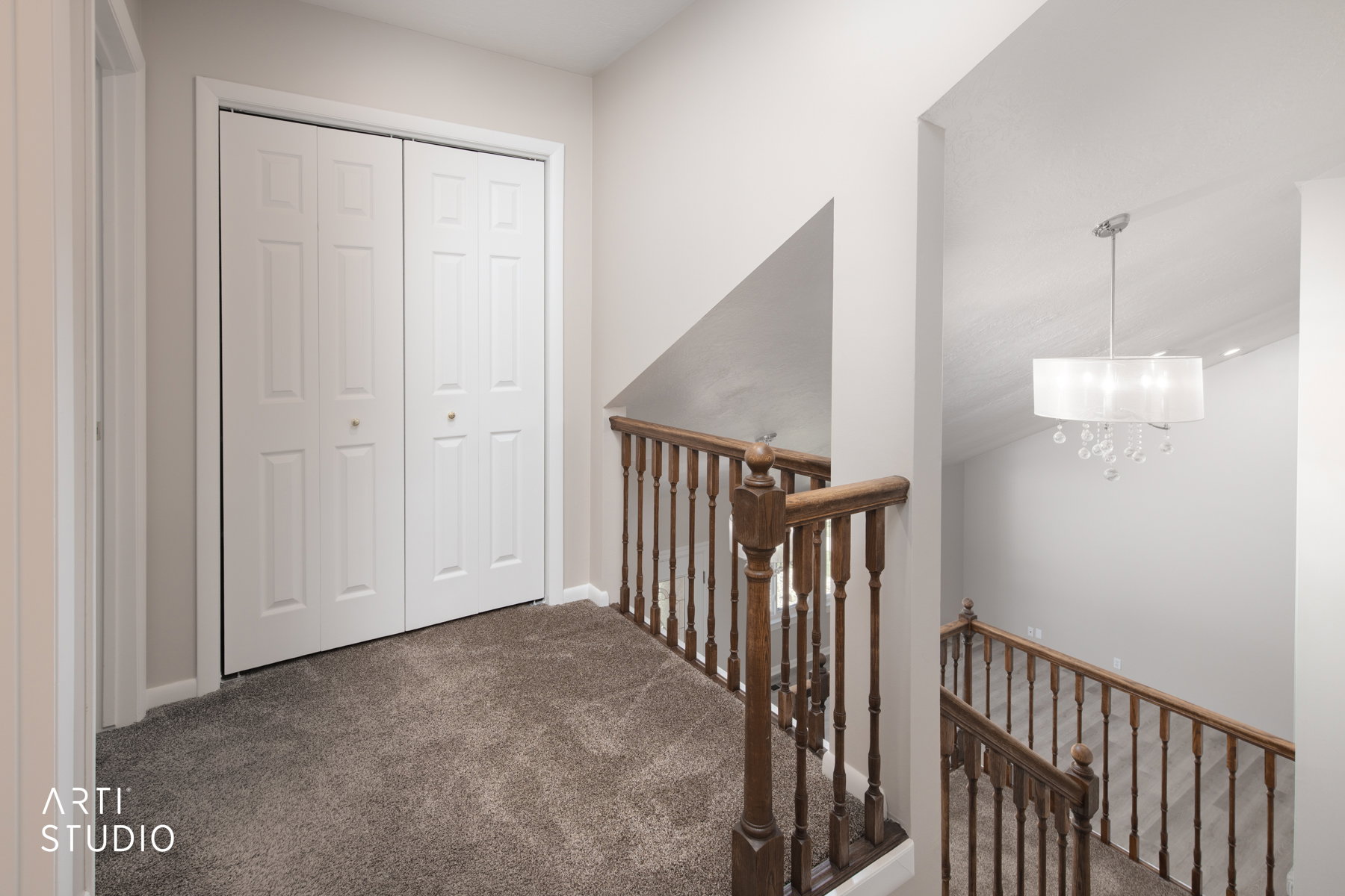 Upper level landing featuring neutral wall paint and plush gray carpet