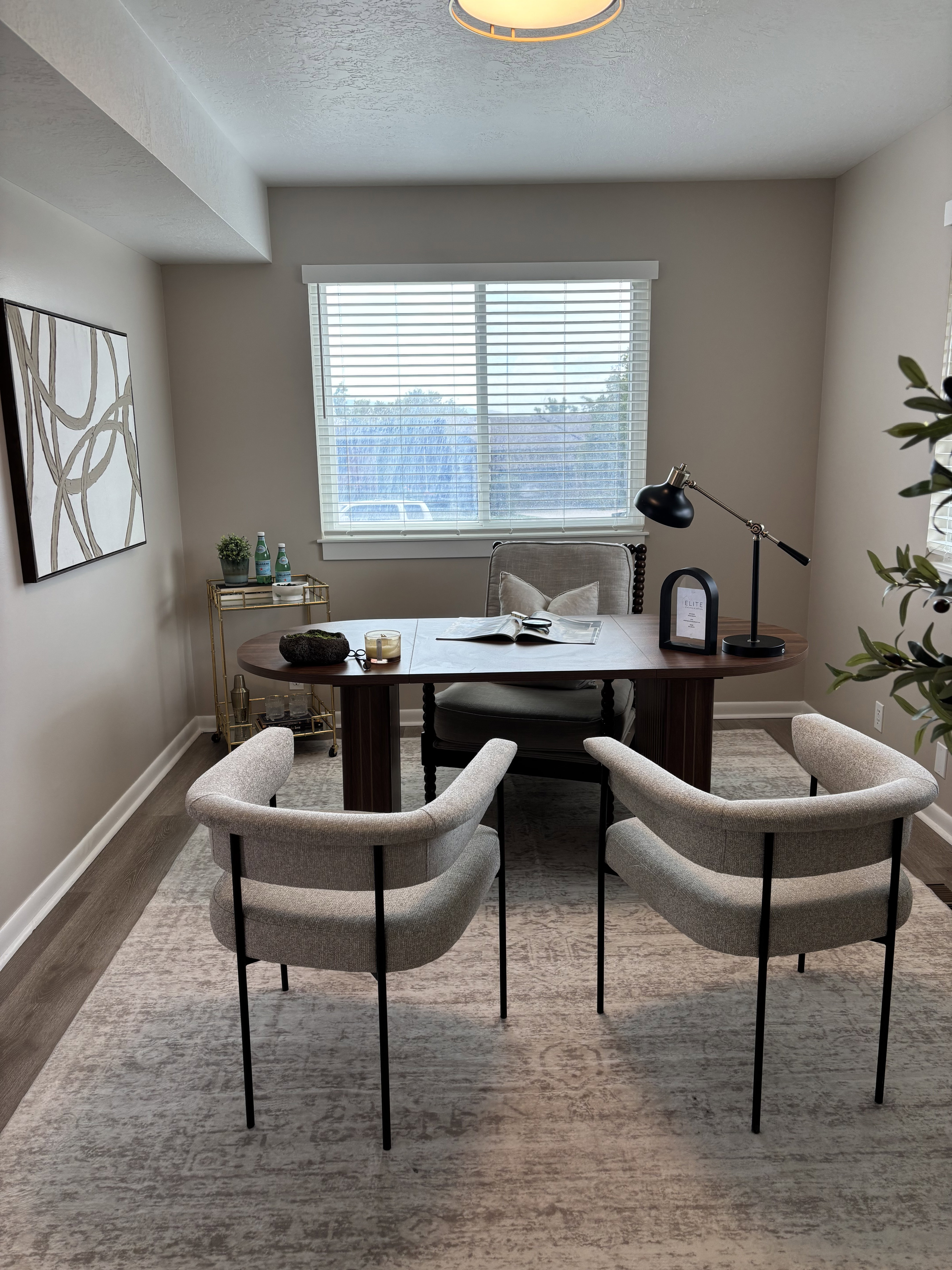 Versatile room featuring a large window, neutral wall tones, wood-finish flooring, white baseboards, and a flush-mount ceiling light