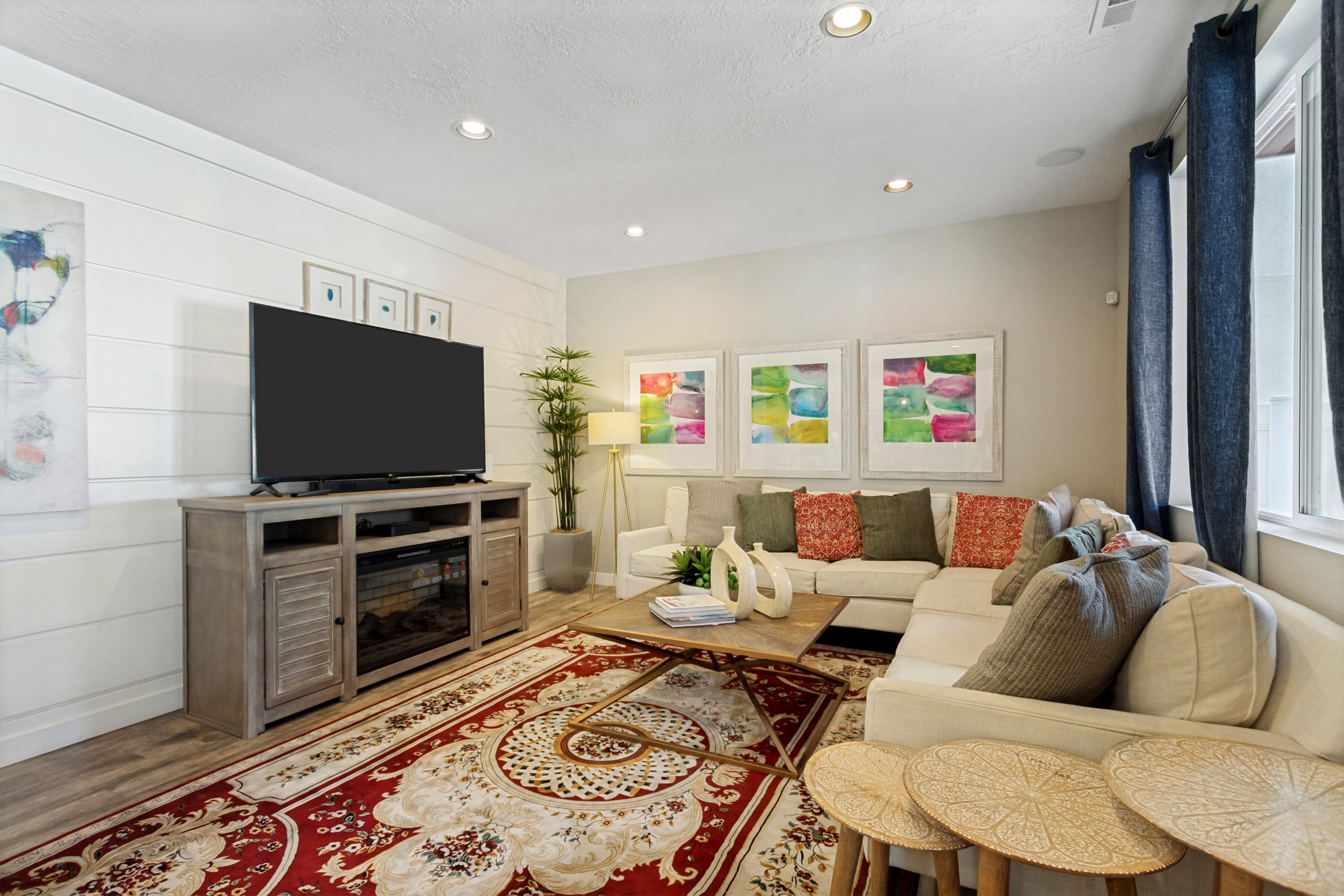 Living area featuring recessed lighting, a built-in entertainment console with an electric fireplace, wood-finish flooring, and white shiplap accent wall