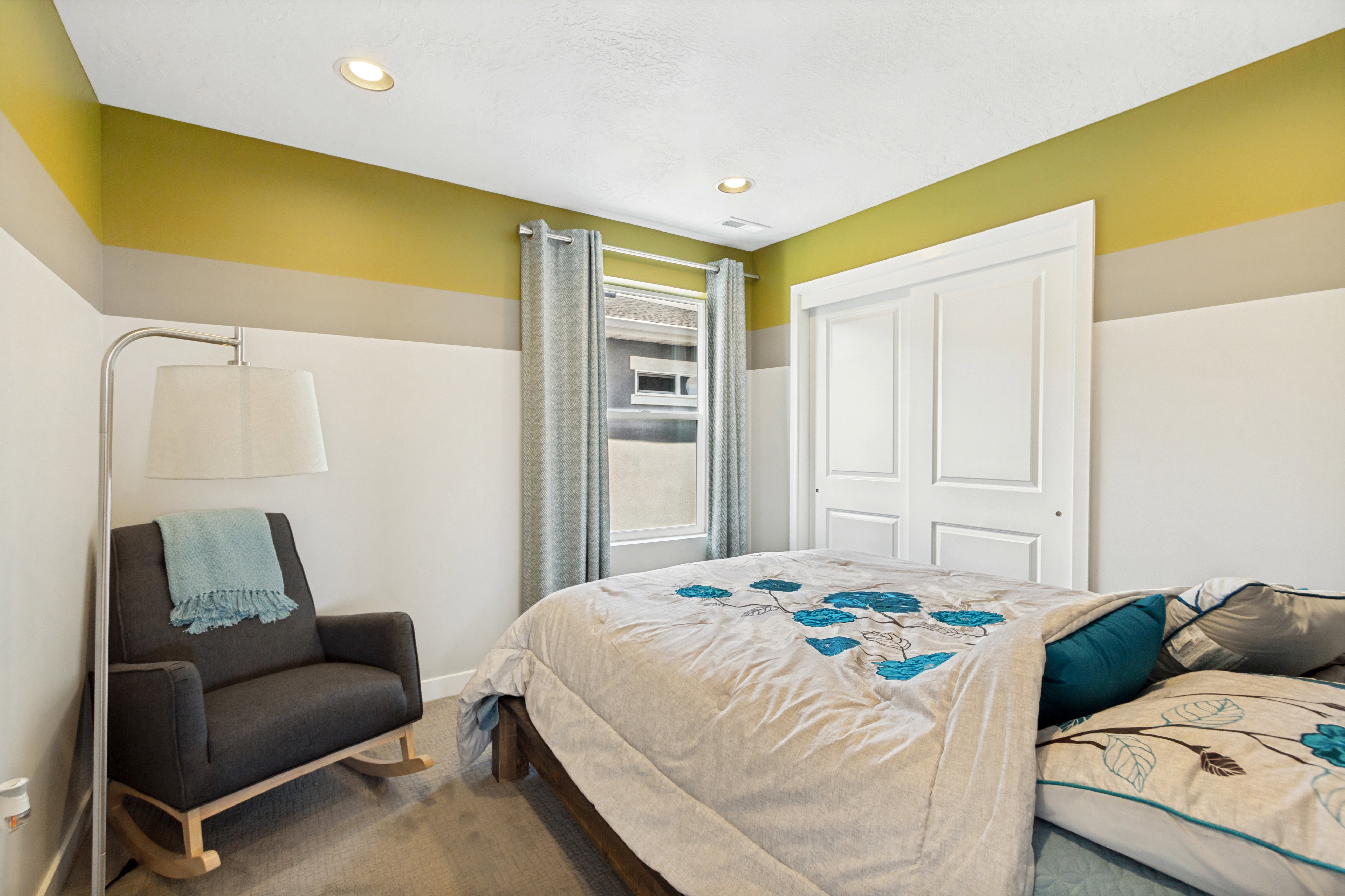 Bedroom featuring recessed lighting, a window with curtains, two-panel bifold closet doors, and carpet flooring