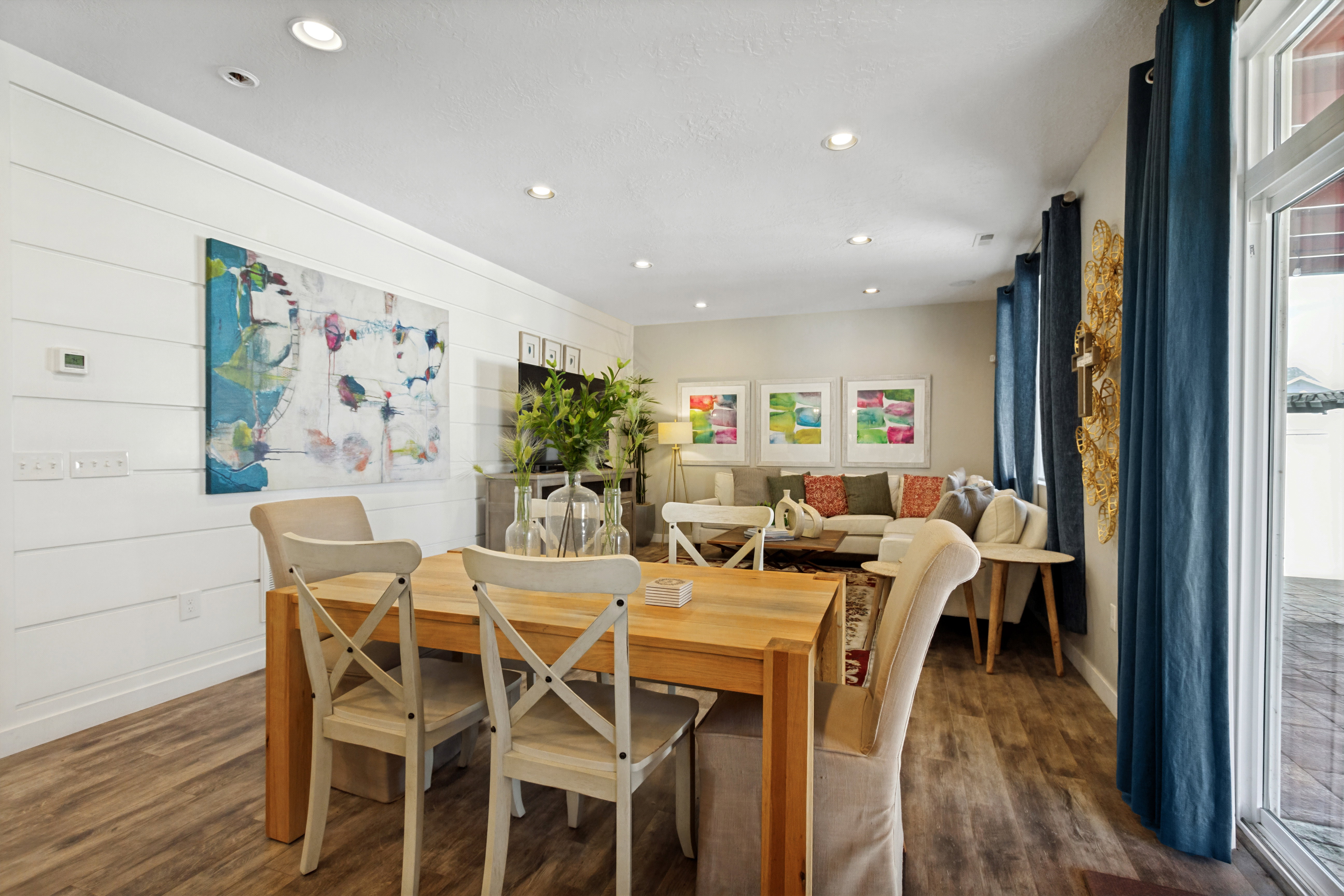 Open-concept living space featuring wood-finish flooring, recessed lighting, and white shiplap accent wall