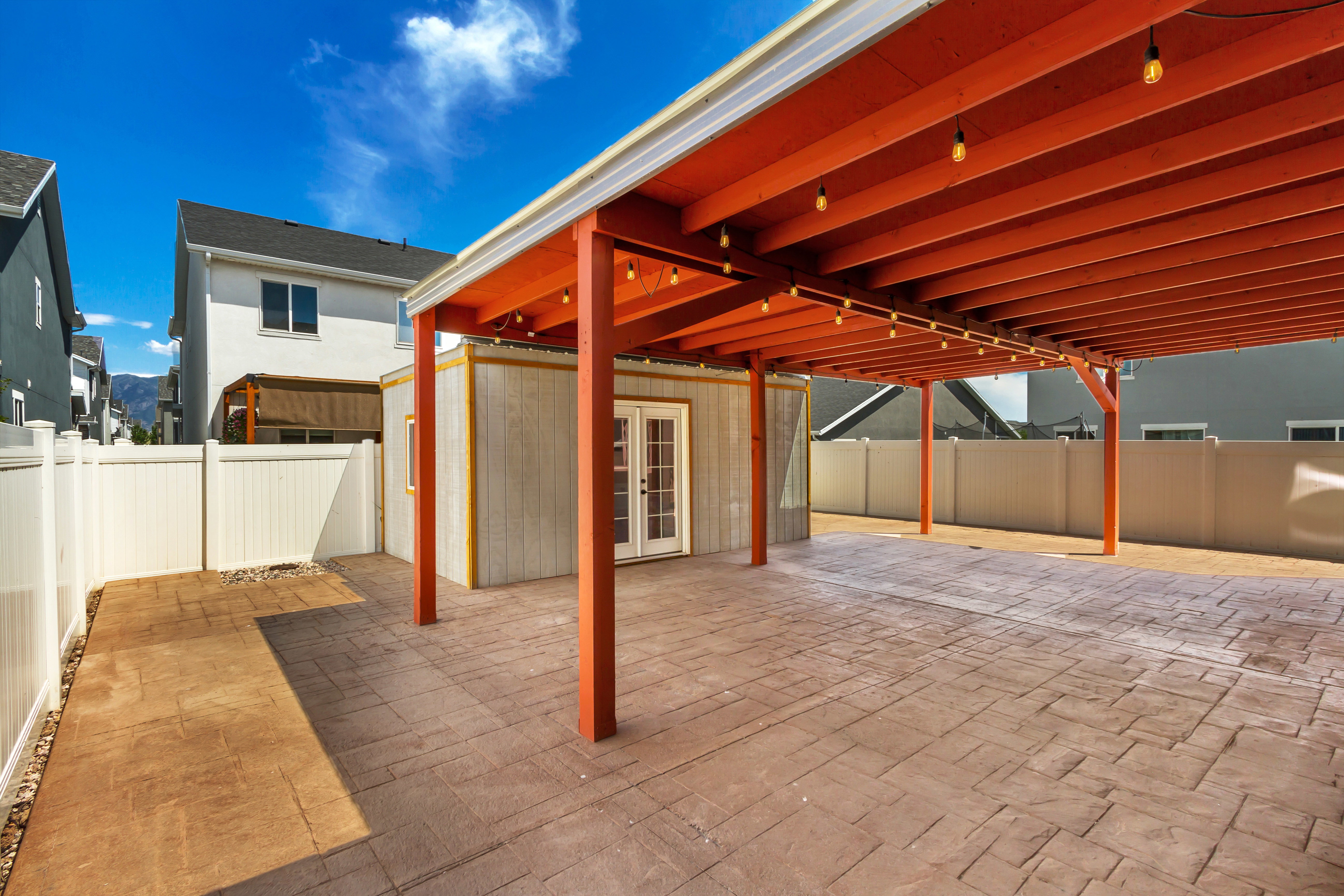 Expansive covered patio featuring stamped concrete flooring and string lighting