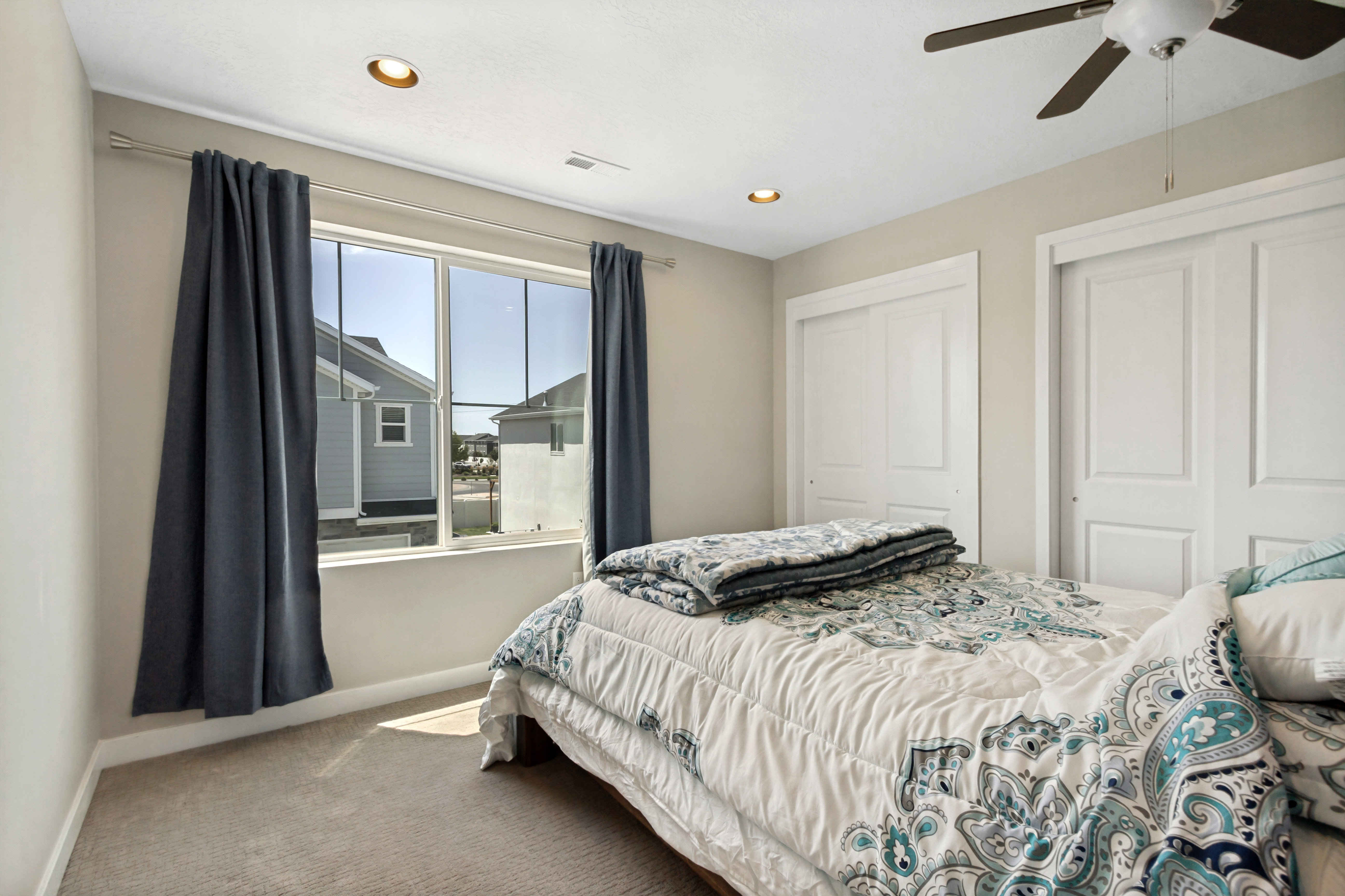 Bedroom featuring a large window, recessed lighting, and a ceiling fan