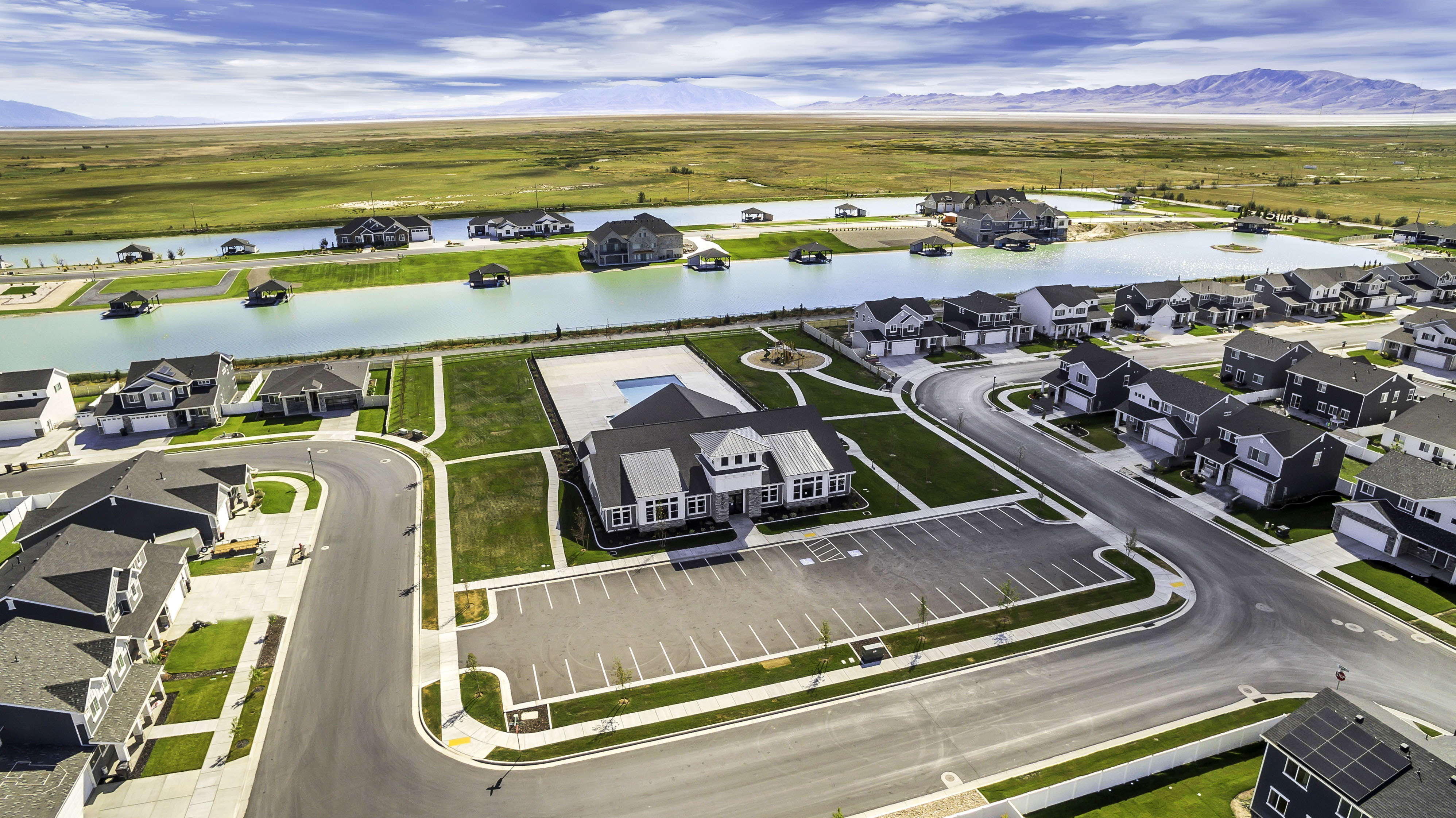 Community with residential properties, a large central building with an outdoor pool, and a water feature with additional structures