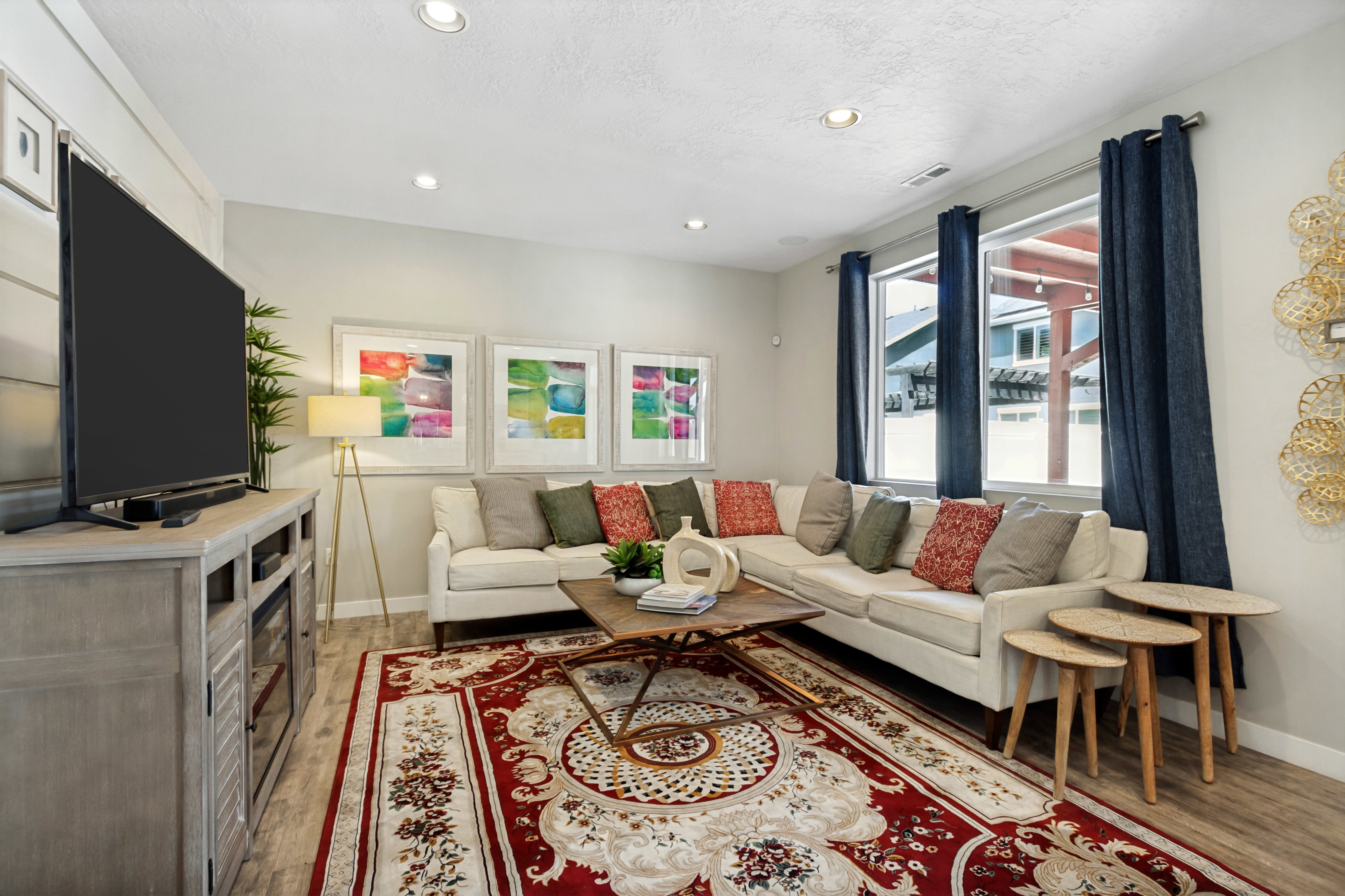 Recessed lighting illuminating the room, featuring wood-finish flooring and multiple windows