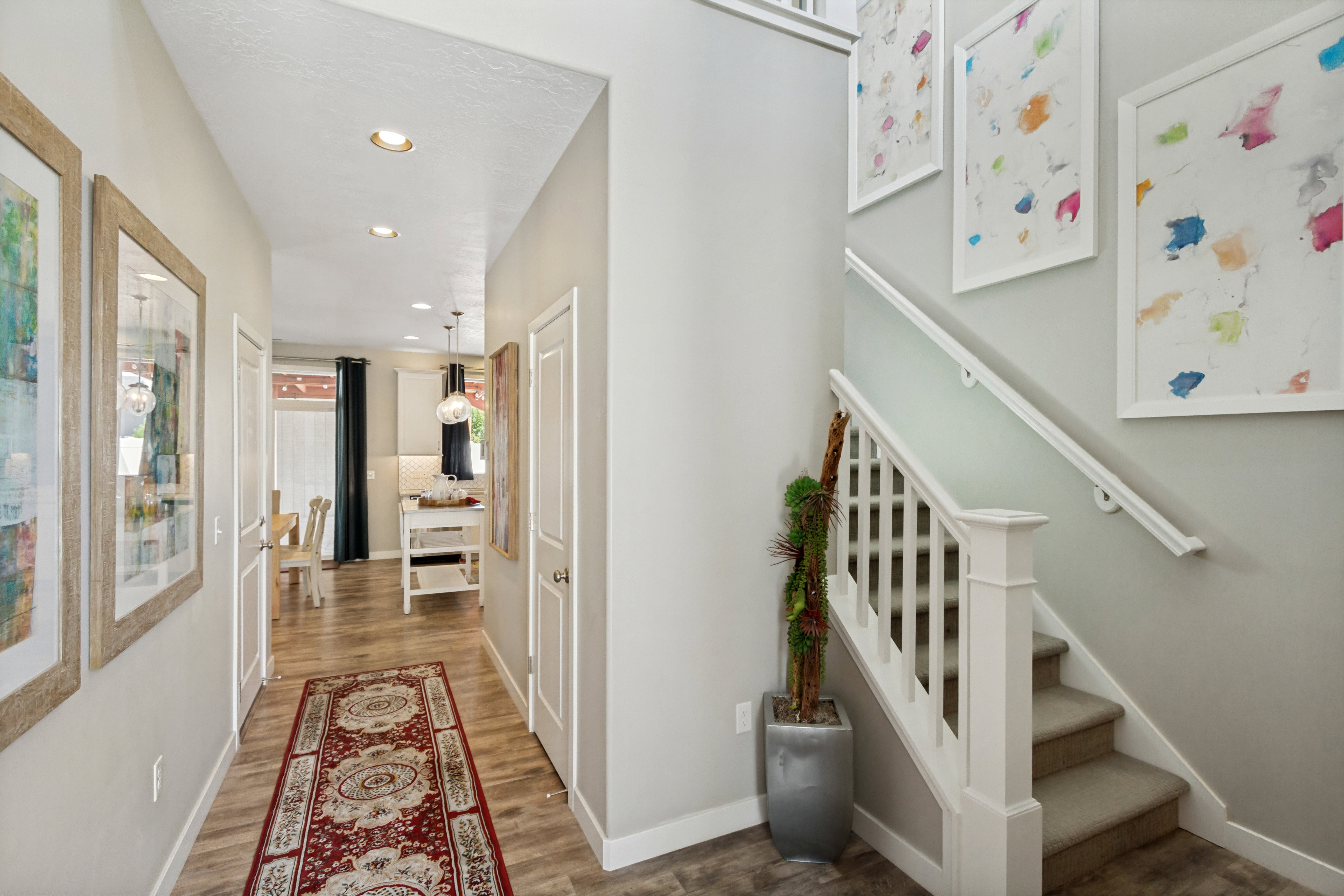 Entryway featuring wood-finish flooring, recessed lighting, and a carpeted staircase with white balusters