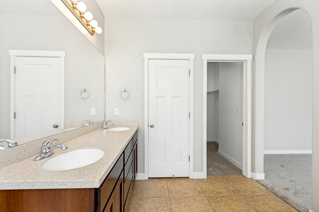 Double vanity with a light-colored countertop, dual undermount sinks, and chrome faucets