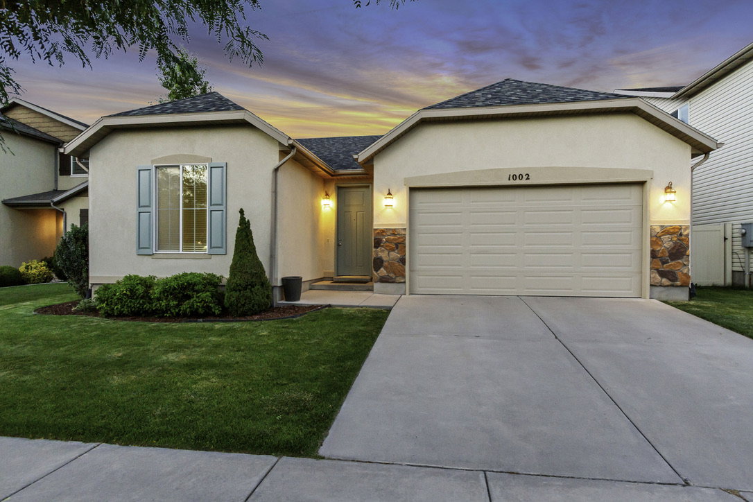 Stucco exterior with stone accents and a concrete driveway