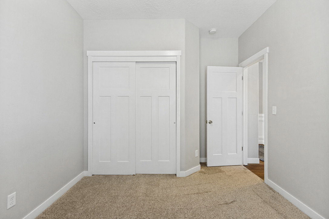 Room featuring neutral-toned carpeting, light gray walls, and white trim