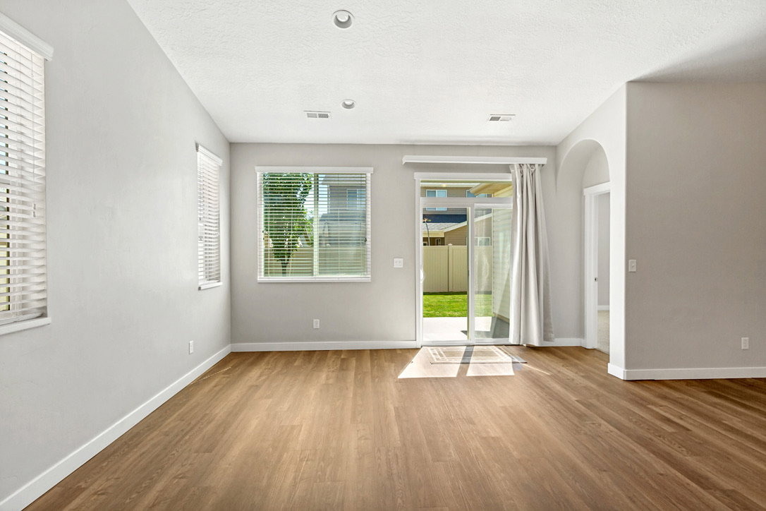 Spacious interior featuring wood-finish flooring, recessed lighting, and multiple windows with blinds