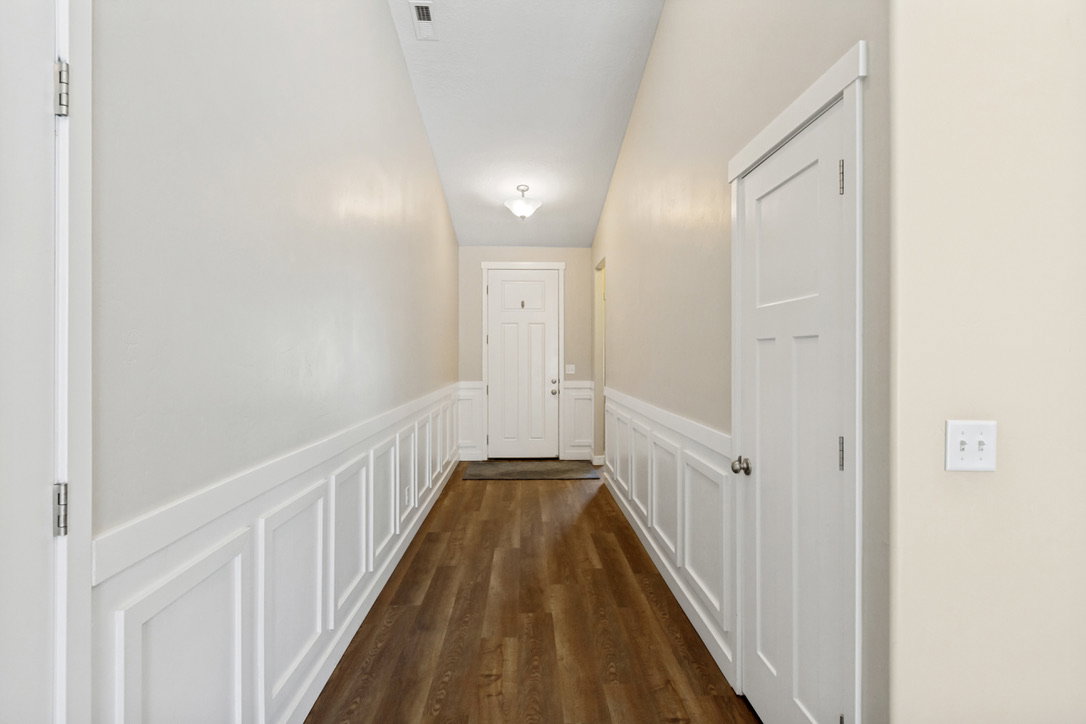 Entryway featuring wood-finish flooring, wainscoting, and a ceiling-mounted light fixture