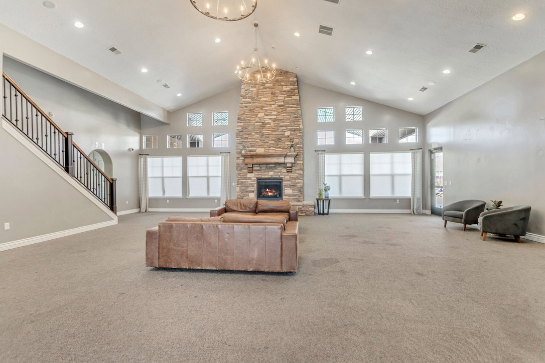 Clubhouse great room featuring a vaulted ceiling with recessed lighting and a central chandelier