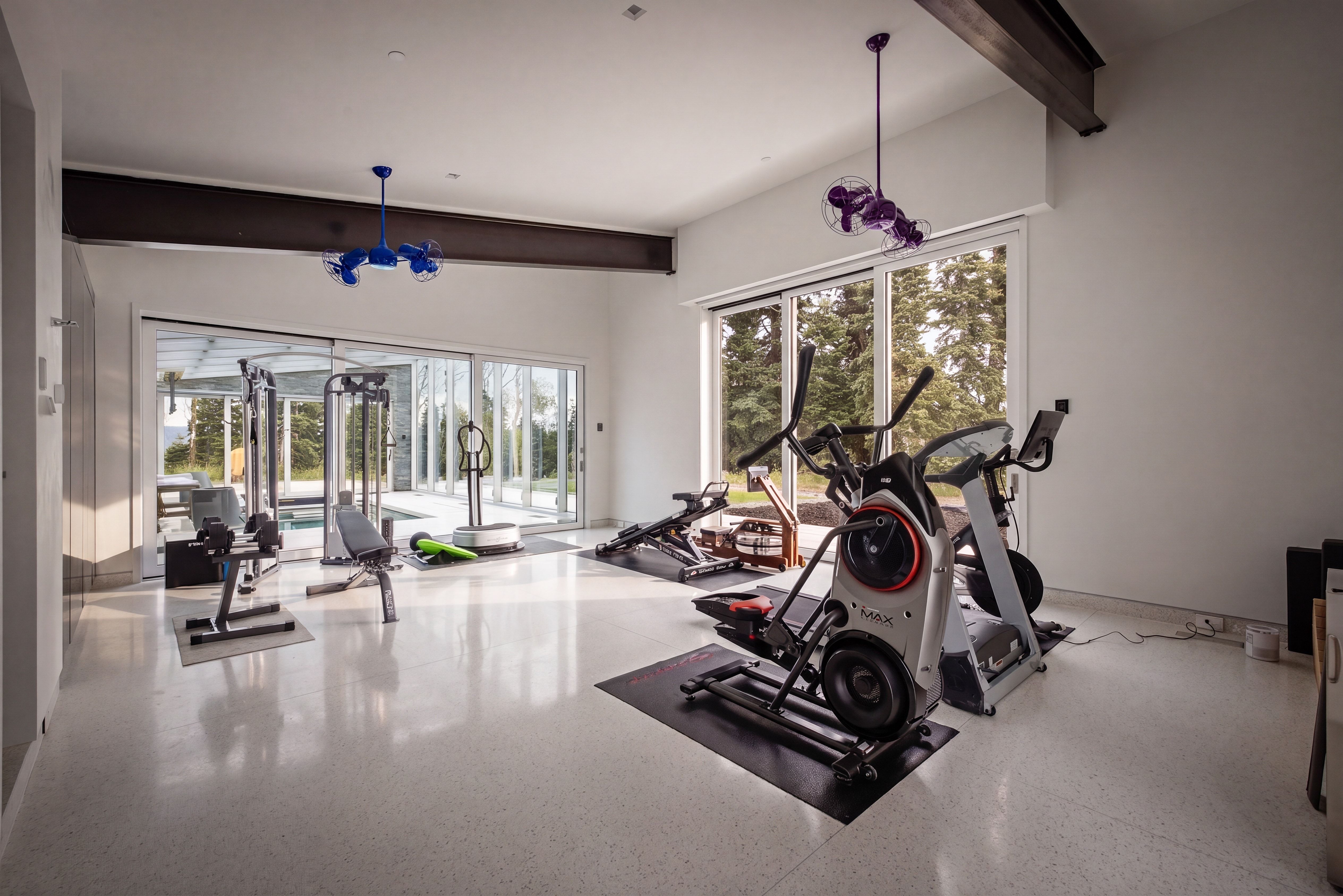 Dedicated fitness space featuring high ceilings with exposed beams, recessed lighting, and polished flooring