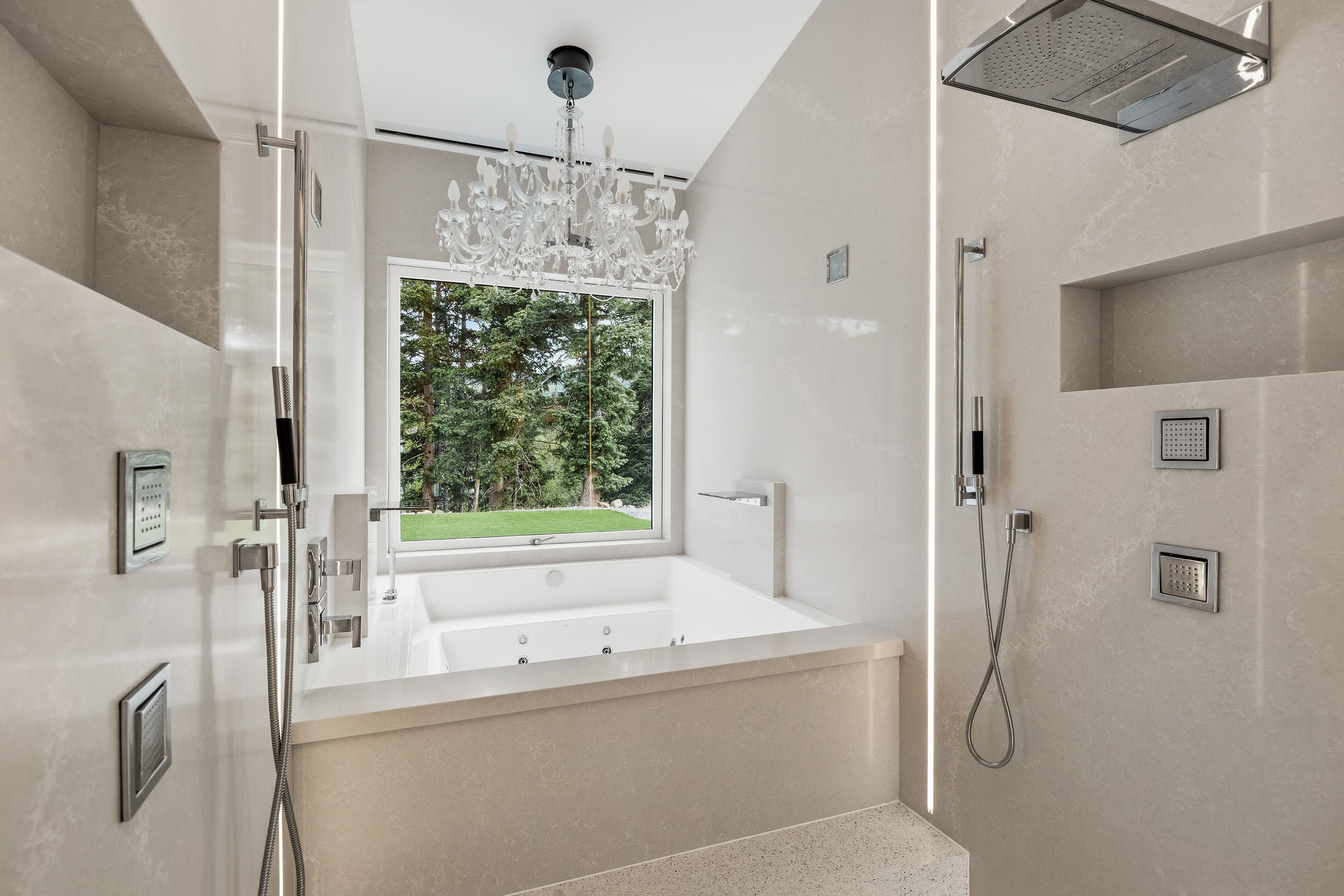 Contemporary bathroom featuring a jetted soaking tub, a large picture window, a crystal chandelier, and a walk-in shower with multiple spray fixtures and a rain showerhead