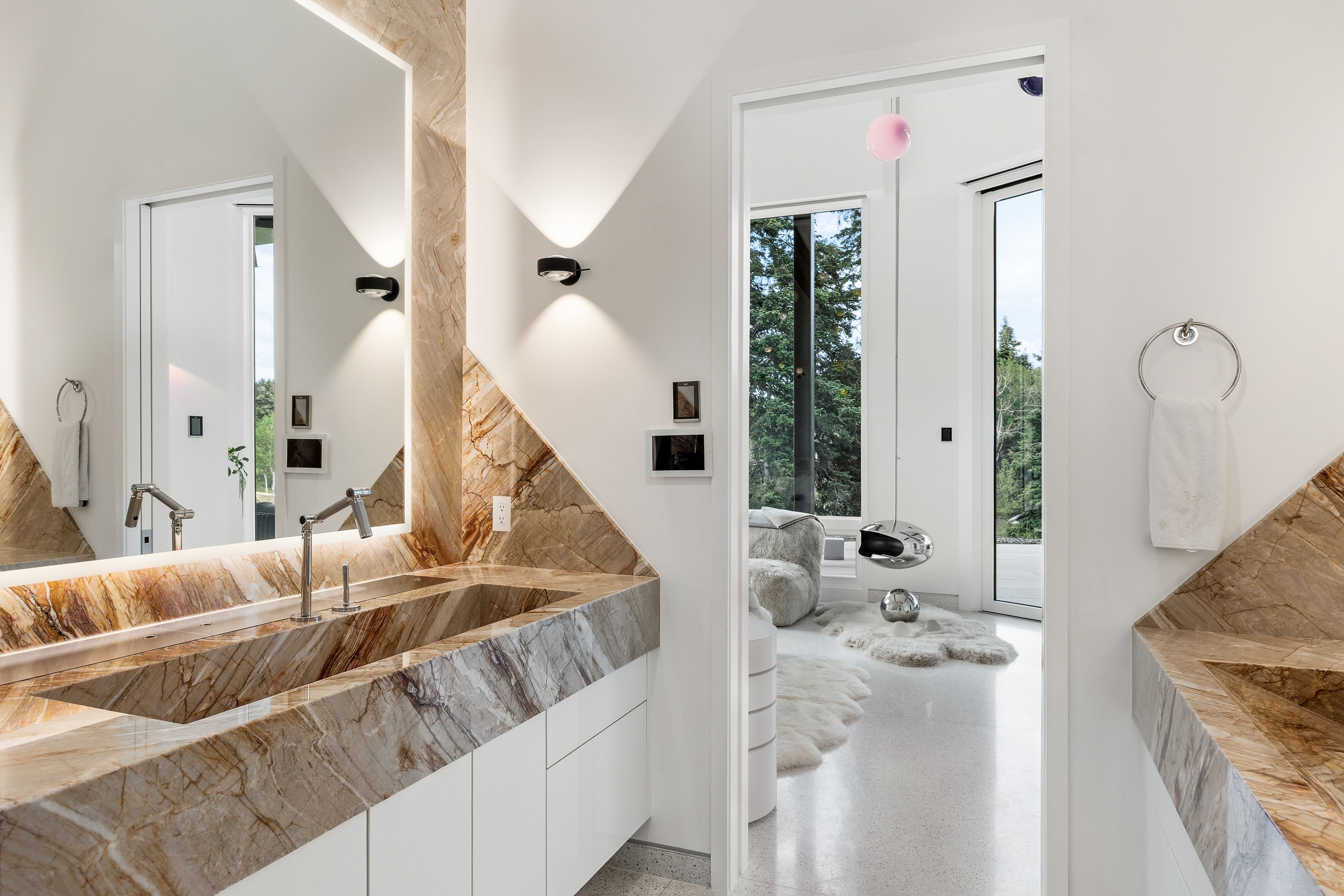 Integrated dual vanity with a single basin, custom stone construction, white cabinetry, and brushed nickel fixtures