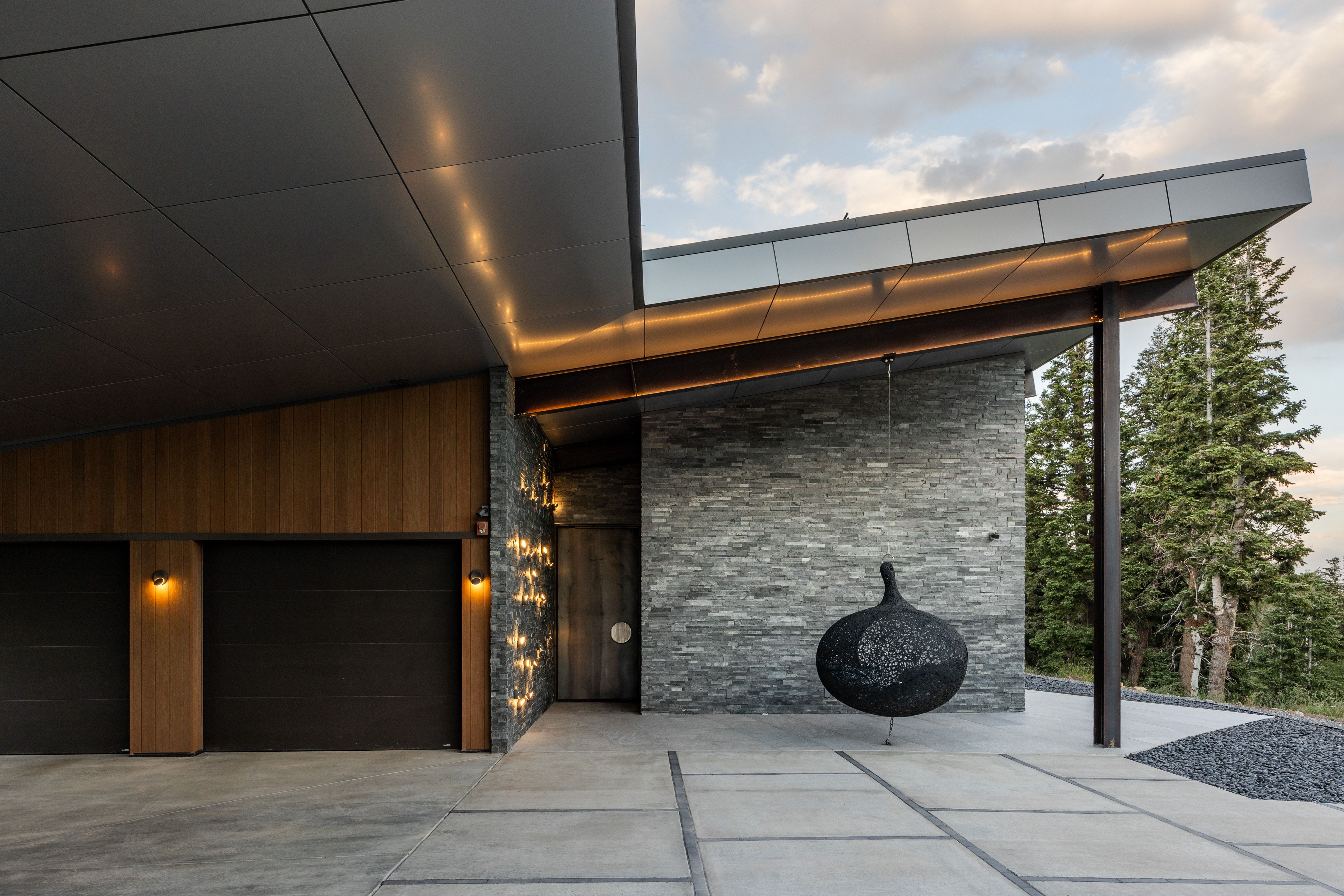 Contemporary exterior featuring stacked stone accents, wood paneling, and a flat roofline